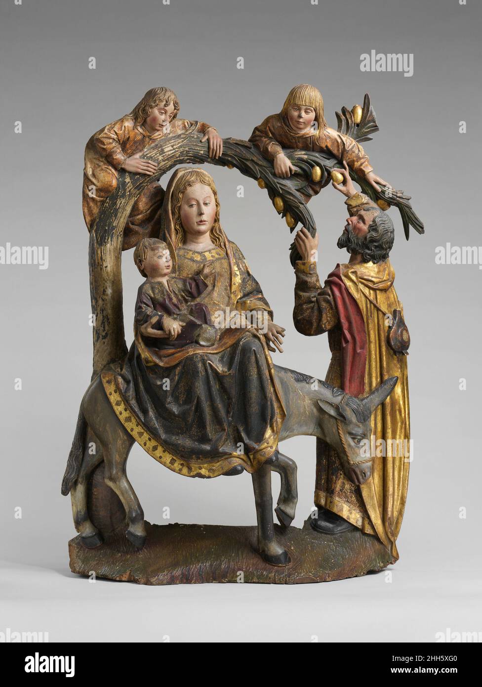 Das Wunder der Palme auf der Flucht nach Ägypten ca. 1490–1510 Spanisch Diese Skulptur, wahrscheinlich von einem Tisch (Dekoration hinter einem Altar), der Jesus zeigt, der die Palme befiehlt, sich zu beugen, damit die Heilige Familie ihre Früchte essen kann, basiert auf neutestamentlichen Apokryphen, Episoden aus dem Leben Jesu, die in den Evangelien nicht erwähnt werden. Die Komposition ist abgeleitet von einem Stich von Martin Schongauer, datiert um 1476. Das Wunder der Palme auf der Flucht nach Ägypten. Spanisch. Ca. 1490–1510. Walnuss, Gesso, Farbe und Vergoldung. Hergestellt in Spanien. Skulptur-Holz Stockfoto