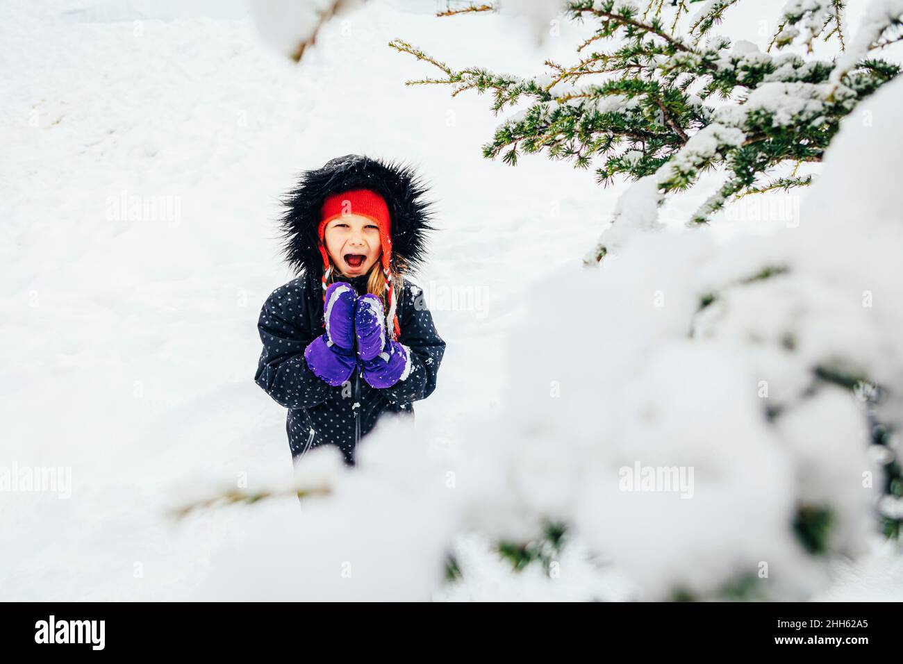 Mädchen trägt Anorak schreiend im Winterurlaub Stockfoto