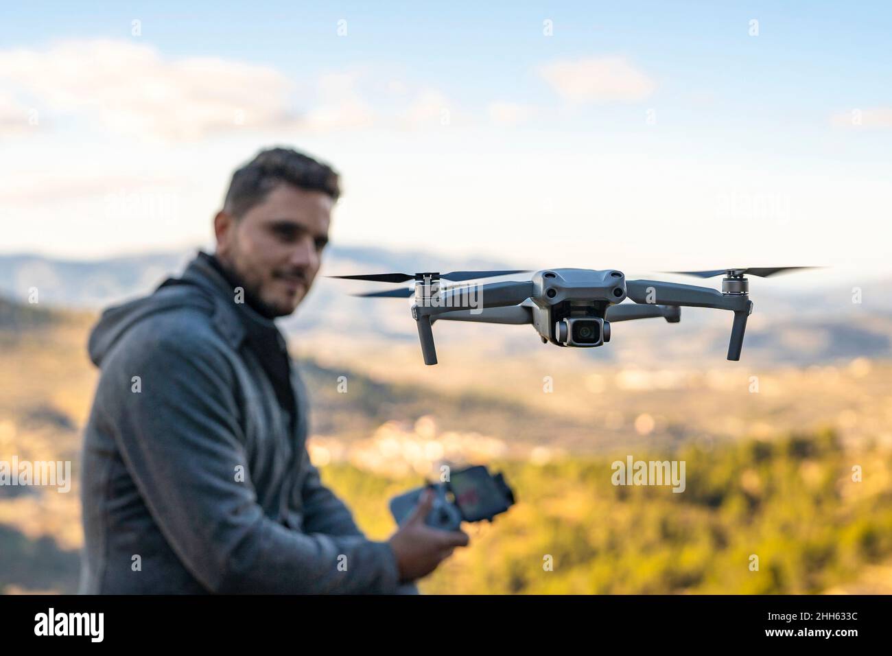 Unbemanntes Luftfahrzeug, das vor dem Drohnenpiloten fliegt Stockfoto