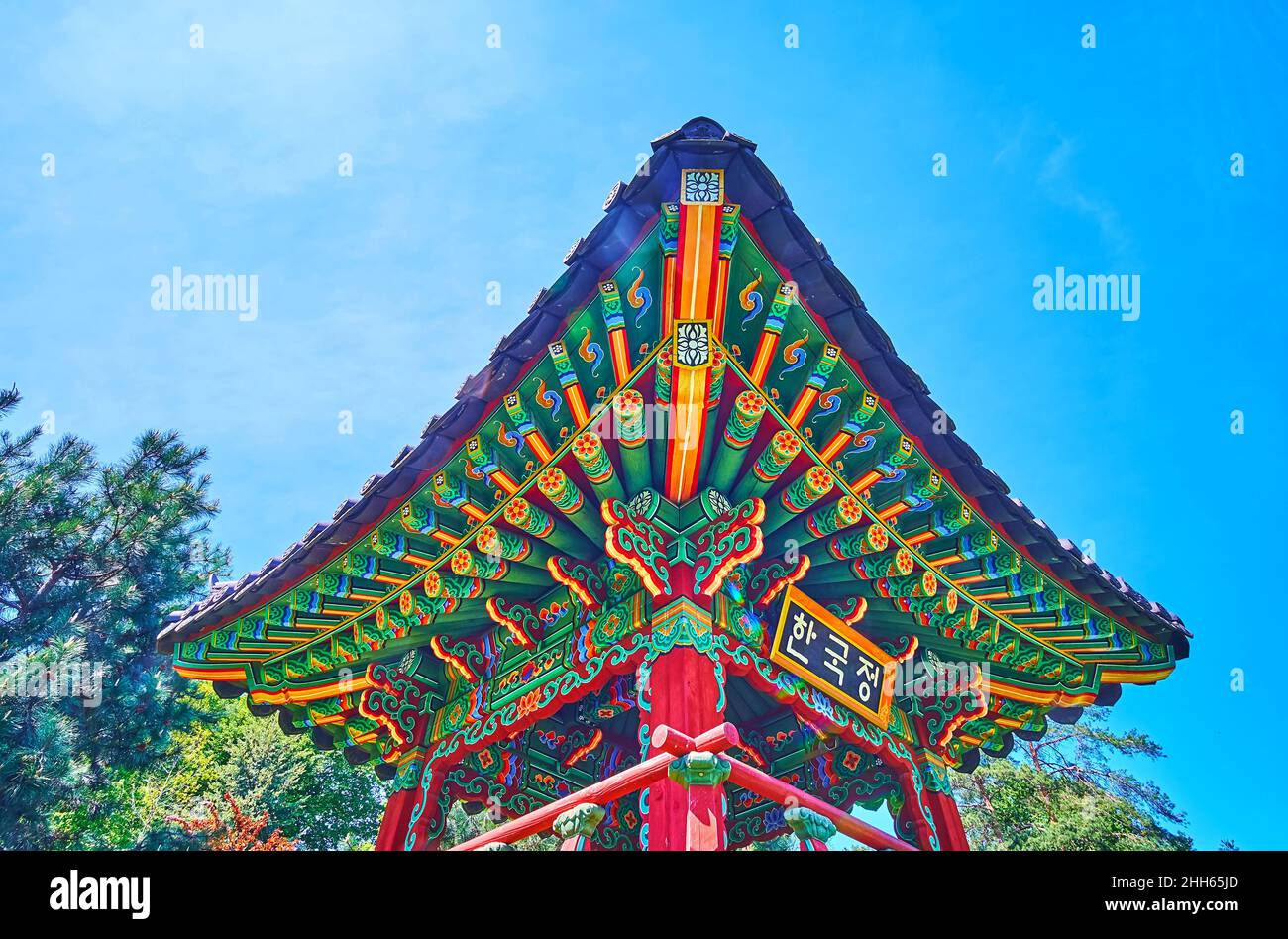 Die farbenfrohe Dachecke der koreanischen Pagode, die mit geschnitzten und bemalten Ornamenten verziert ist, befindet sich im traditionellen koreanischen Garten, Kyiv Botanical GA Stockfoto Die farbenfrohe Dachecke der koreanischen Pagode, die mit geschnitzten und bemalten Ornamenten verziert ist, befindet sich im traditionellen koreanischen Garten, Kyiv Botanical GA Stockfoto