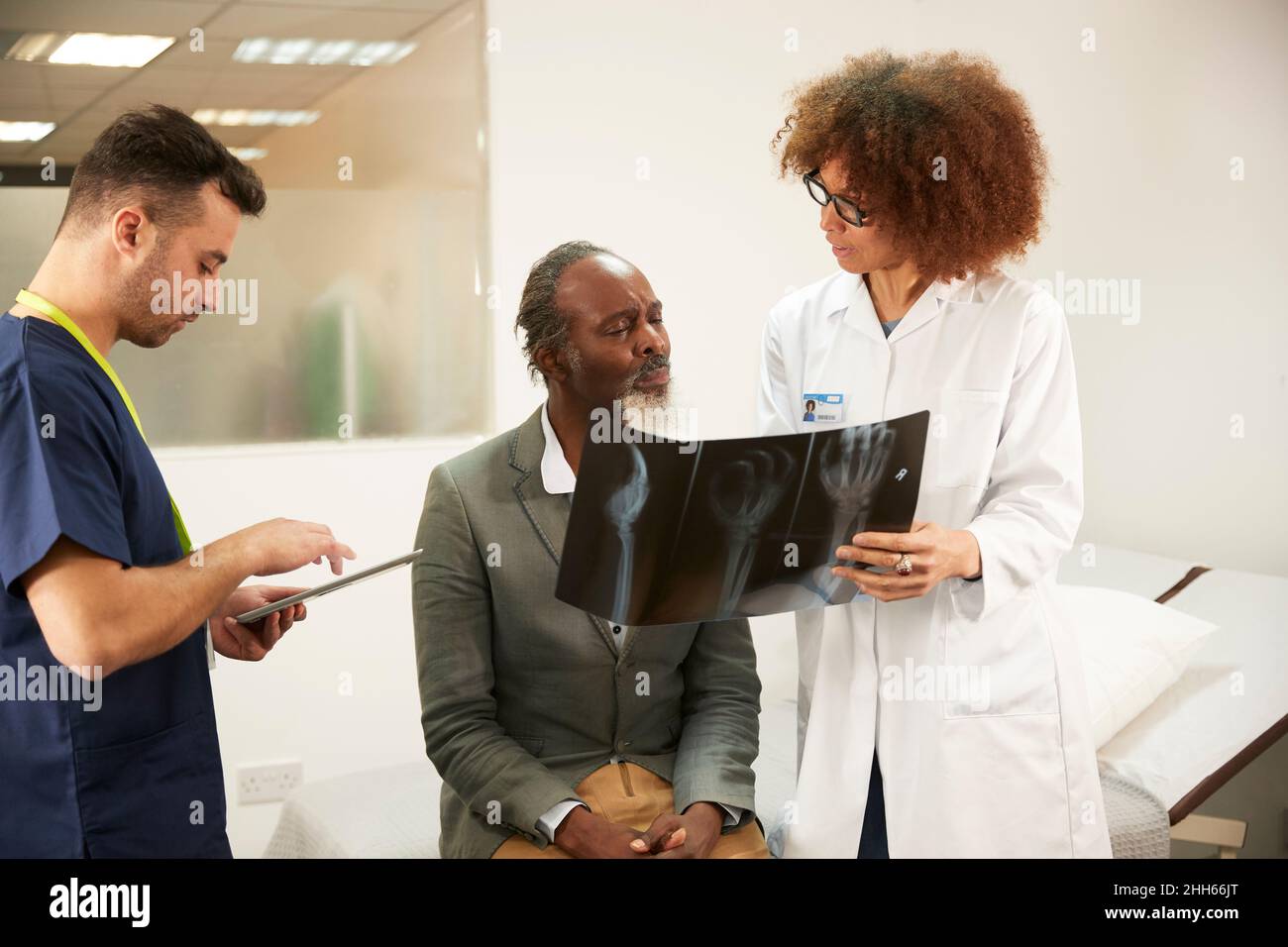 Arzt bespricht Röntgenbericht mit Patient im medizinischen Raum Stockfoto