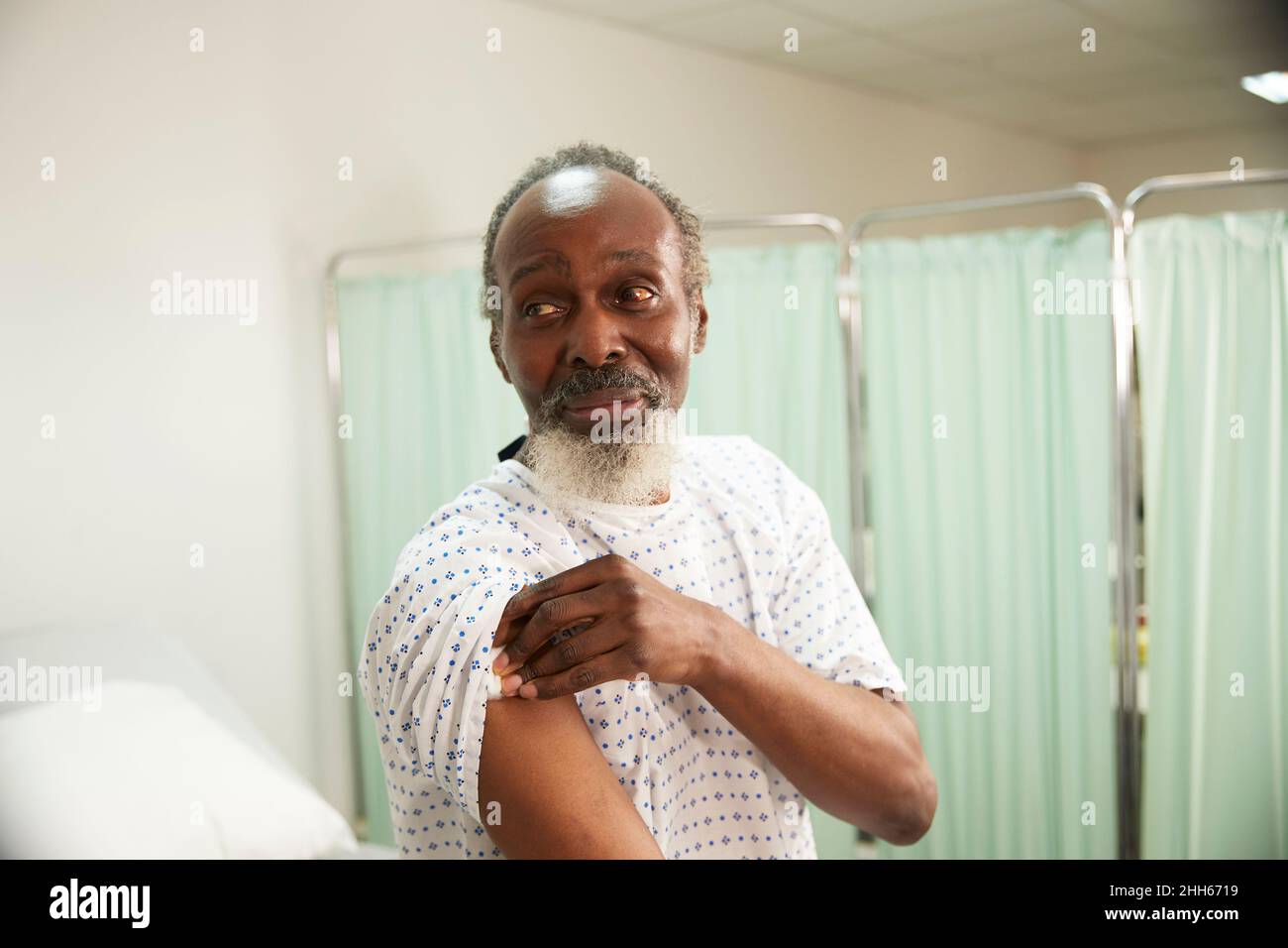 Patient hält Wattebausch am Arm im medizinischen Raum Stockfoto