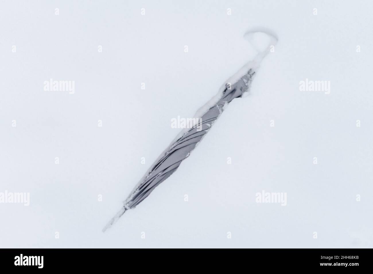 Grauer Regenschirm im Schnee Stockfoto