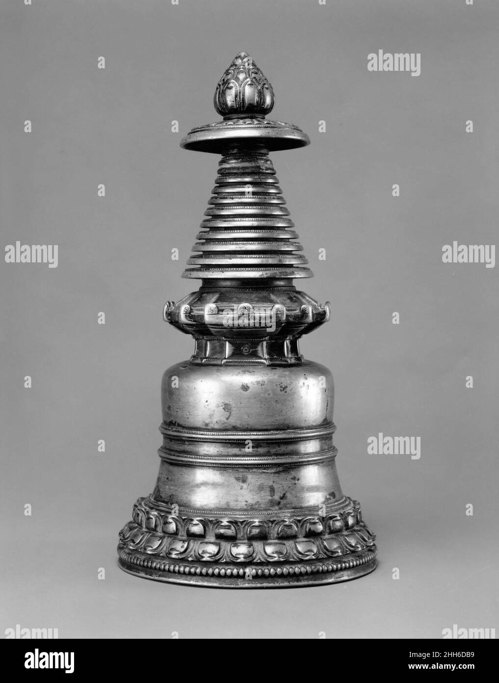 Stupa Westtibet des 13th. Jahrhunderts Gedenkstupas (tibetanisch: chorten) sind die ältesten Symbole des Buddhismus und wurden zum Sinnbild sowohl des Dharma als auch des Buddha selbst. Repositorien für Reliquien, die mit dem Buddha, seinen Schülern und ihren Abstammungen in Verbindung gebracht wurden, nahmen sie einen zentralen Platz in der späteren buddhistischen Bildsprache ein. Tragbare Versionen enthalten oft Reliquien bedeutender Mönche oder heiliger Texte. Stupa. Westtibet. 13th Jahrhundert. Messing. Metallverarbeitung Stockfoto