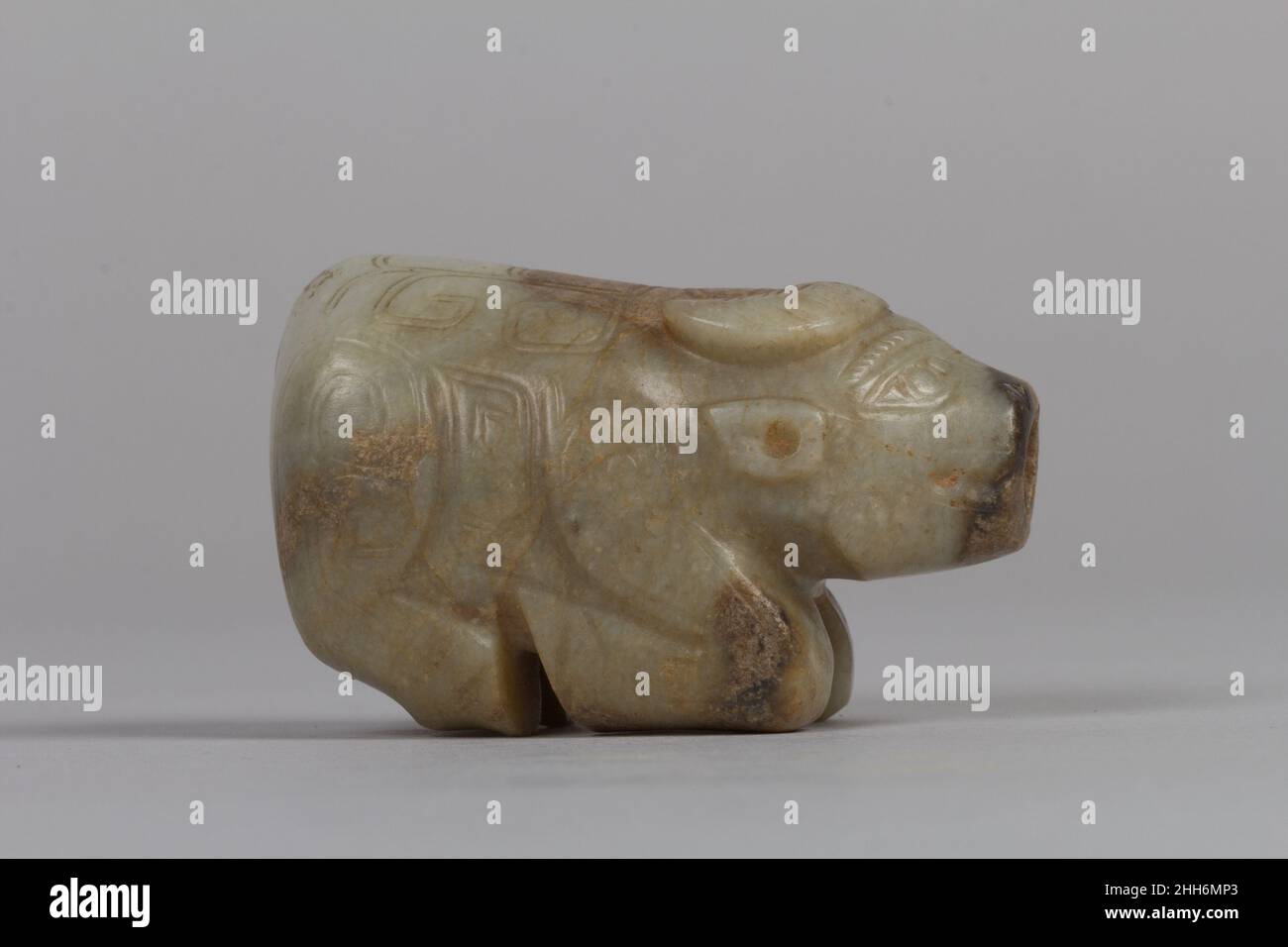 Wasserbüffel 13th.–11th. Jahrhundert v. Chr. China eine der Innovationen der Shang Jade Schnitzerei war die Schaffung von Figuren in der Runde. Die Künstler schmückten diesen Wasserbüffel außerdem mit Spiralen, die an bronzene dekorative Motive erinnern. Sie schufen die Illusion, dass die Muster angehoben wurden, indem sie die Oberfläche mit zwei leicht abgeschrägten parallelen Linien gravierten. Ein Loch, das den Mund und die Unterlippe der Figur durchdringt, deutet darauf hin, dass es wahrscheinlich als Ornament oder Talisman getragen wurde. Wasserbüffel. China. 13th–11th Jahrhundert v. Chr.. Jade (Nephrit). Shang-Dynastie (ca. 1600–1046 V. CHR.). Jade Stockfoto