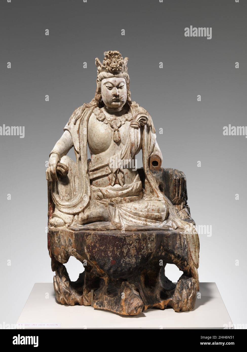 Bodhisattva Avalokiteshvara in Wassermondform (Shuiyue Guanyin) aus dem Jahr 1385 China Diese mächtige Figur gehört zu einer kleinen Gruppe von Holzskulpturen, die sicher datiert werden können, dank einer Inschrift, die auch seltene Informationen über ihre Herstellung und ihren Verwendungszweck liefert. Die Inschrift erscheint auf der Innenfläche einer abnehmbaren Tafel auf der Rückseite der Figur, die Zugang zu einer Kammer bietet, die einst Konsekratorium enthielt. Sie besagt, dass die Skulptur 1385 unter der Leitung eines bestimmten Xin Zhongwen geschnitzt wurde, der zusammen mit Mitgliedern des Dorfes Dongan Th in Auftrag gab Stockfoto