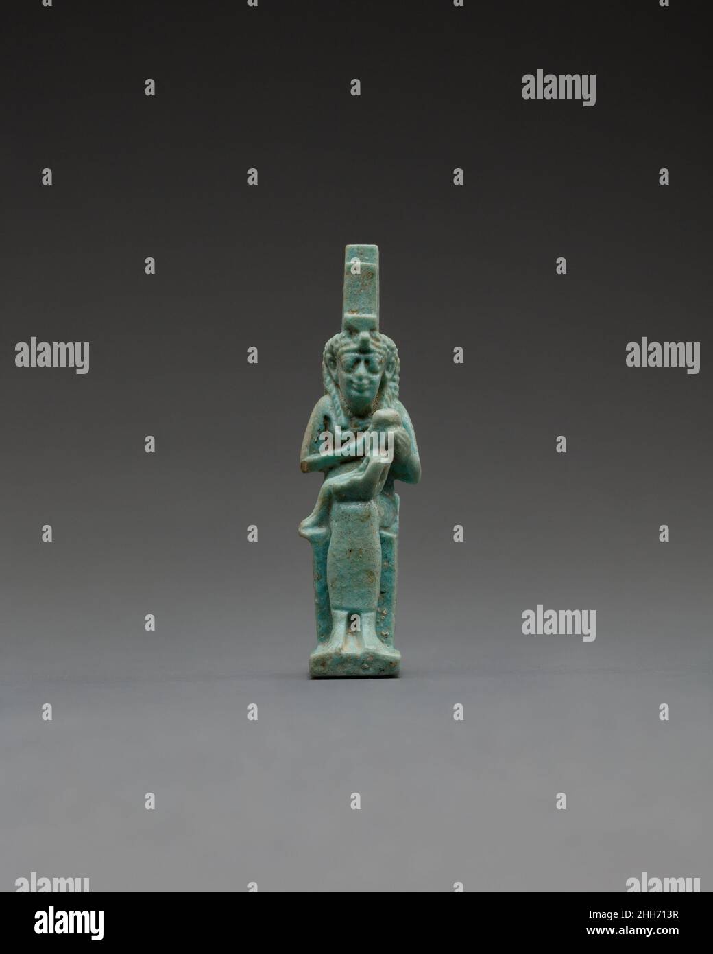 Figur des Isis-Pflegepersonals Horus ca. 332–30 v. Chr. Ptolemäische Periode Dieses Amulett zeigt Isis lactans, Isis stillende Horus, ihren posthumen Sohn mit dem gott Osiris. Die Göttin, identifiziert durch die Thronhieroglyphe auf ihrem Kopf, sitzt auf einem Blocksitz, der an der Seite mit einem Federmuster geschmückt ist und vielleicht die Flügel symbolisiert, mit denen sie gezeigt werden kann, oder ihre Form als Drachen (Raubvögel). Ein gefaltetes Tuch wird so dargestellt, als würde es den Sitz bedecken und über die niedrige Rückenlehne drapieren. ISIS wurde als die Verkörperung einer schützenden, pflegenden Mutter angesehen; kleine Figuren wie diese hätten diese Eigenschaften für hervorgerufen Stockfoto