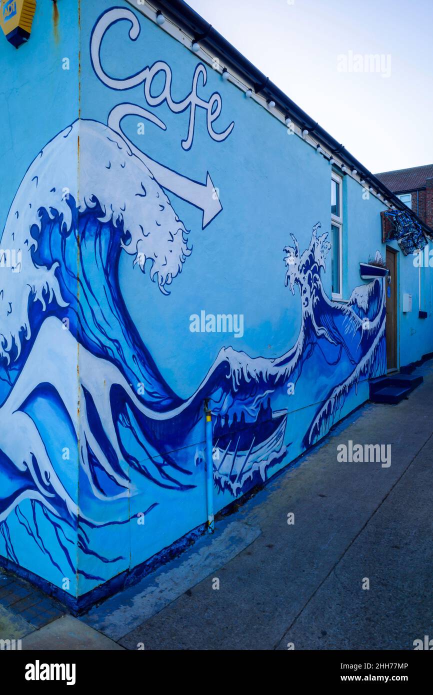 Zetland Café am Meer in Redcar mit Außenfassade dekoriert mit blau gestrichenen Wellen und lokalen Fischerbooten Stockfoto