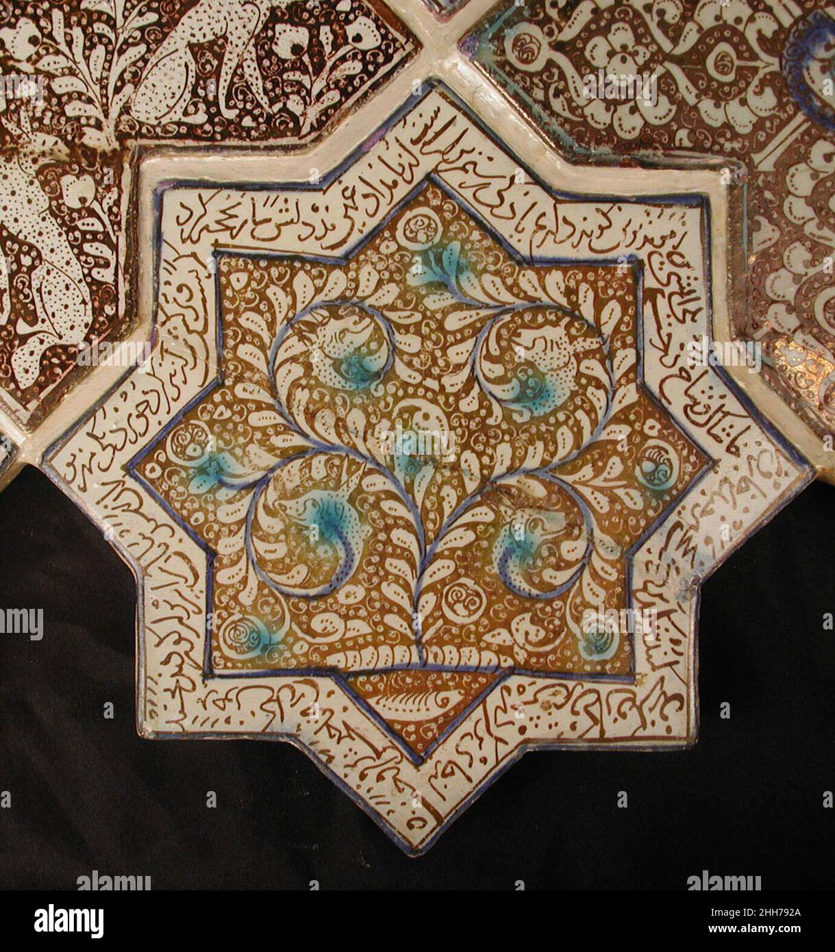Sternförmige Fliese 13th–14th Jahrhundert Diese achtzackige Sternziegel war einst Teil einer Platte aus Stern- und kreuzförmigen Fliesen, die die Wände eines Ilkhanid-Gebäudes schmückt. Wahrscheinlich im Keramikzentrum von Kashan hergestellt, zeigt es das waq-waq-Design einer Pflanze, deren Ranken sich zu Tierköpfen entwickeln, ein Merkmal, das während der Seldschuken-Zeit in den Iran kam. Der persische Text, der am Rand der Kachel verläuft, ist ein Auszug aus dem Shahnama, in dem Rustam, einer der großen Helden der Geschichte, in den Kampf verwickelt ist. Sternförmige Fliese 450427 Stockfoto