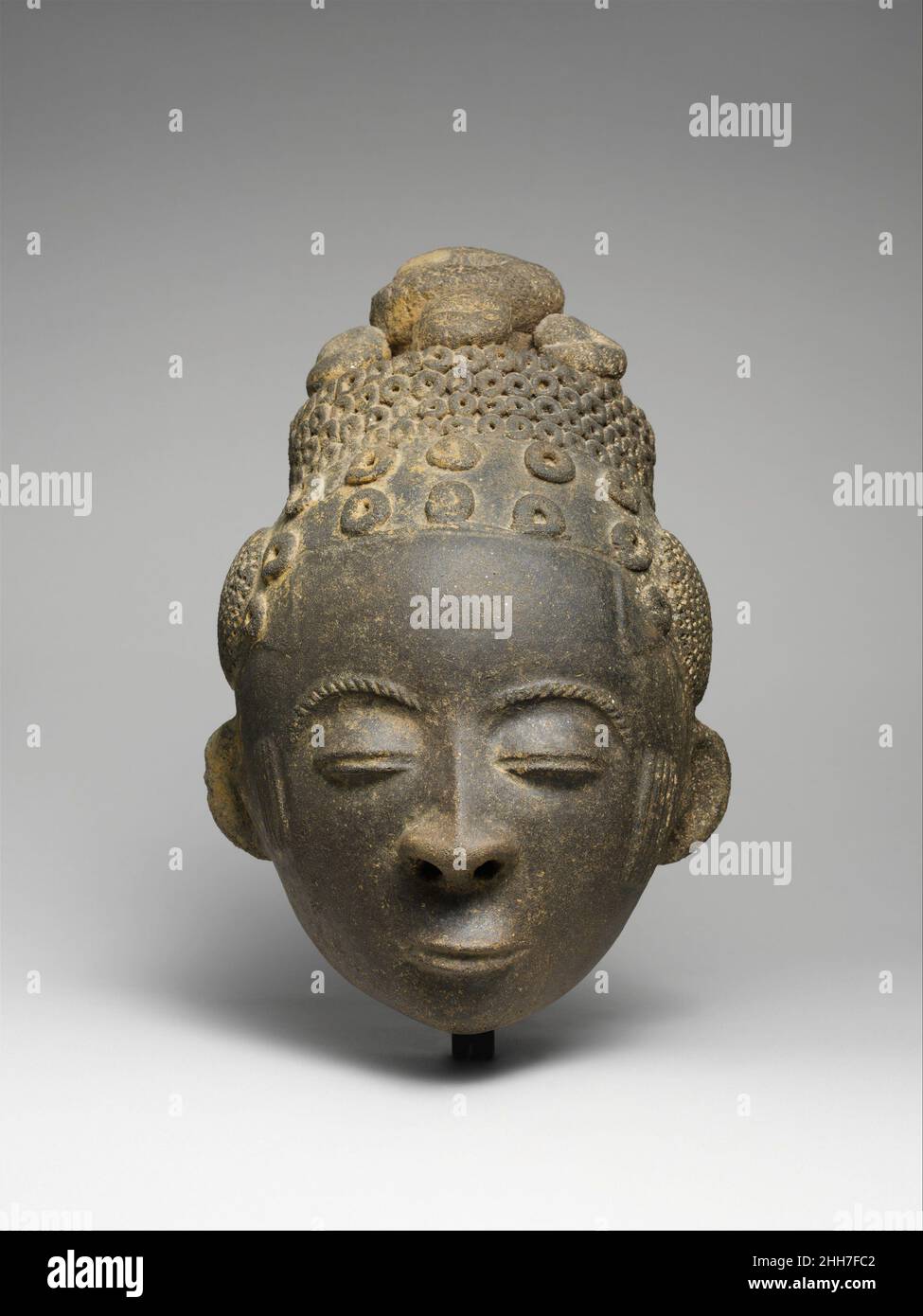 Memorial Head (Nsodie) ca. 1800 Akan-Völker dieser elegante Terrakotta-Kopf ist ein Gedenkporträt (Nsodie) eines Akan-Herrschers aus dem heutigen Süden Ghanas. Es handelt sich um eine idealisierte Darstellung, deren ruhiger Ausdruck und ausgewogene Merkmale die positiven Eigenschaften andeuten, die solche Herrscher verkörpern sollen. Posthum entstanden, wurden königliche Bilder wie diese mit den Porträts früherer Herrscher in heiligen Bereichen innerhalb des Friedhofs platziert, die als „Asensie“ bezeichnet wurden. Im Allgemeinen wurde jede königliche Figur von Skulpturen von Höflingen und Dienern begleitet, vielleicht um dem Verstorbenen in t Hilfe und Trost zu bieten Stockfoto