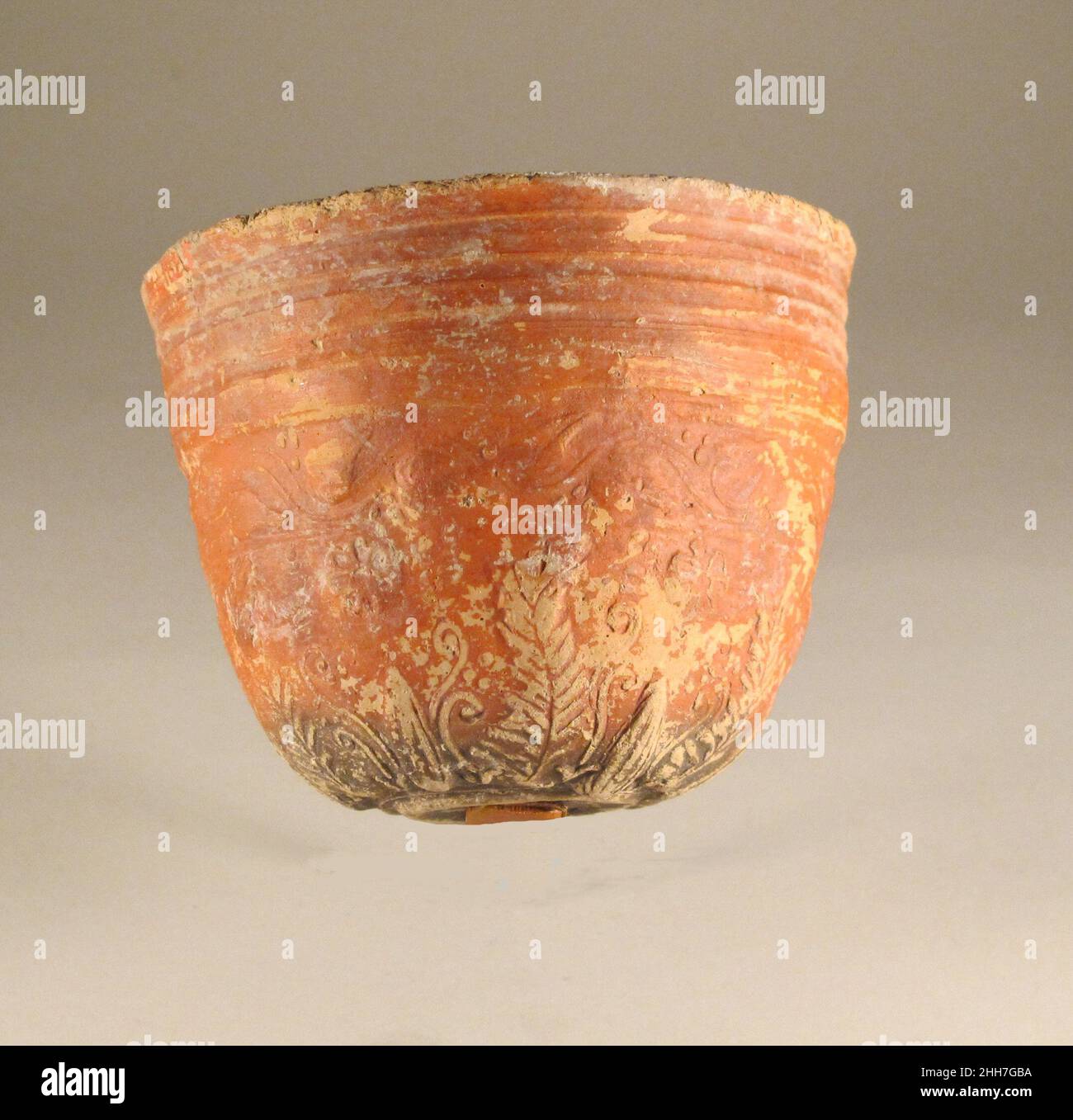 Terracotta Megarian Schale 1st Jahrhundert v. Chr. Griechisch, Pergamene gerillte Grate über einer Zone von Herz-Efeu mit Beeren von Bändern eingerahmt; Unten abwechselnd Lotus- und Akanthus-Blätter mit Ranken, durchsetzt mit siebenblättrigen Rosetten.Rotglasierte Schalen wie diese wurden in Pergamon zwischen dem 2nd. Und 1st. Jahrhundert v. Chr. hergestellt.Neben ihrer charakteristischen Glasur zeichnen sich viele dieser Schalen durch ihre höheren, zylindrischeren Profile aus. Und die Platzierung der dekorativen Motive auf der unteren Hälfte der Außenfläche der Schale. Obwohl getragen, wird die frei-Stil Relief Dekoration sorgfältig gerendert Stockfoto