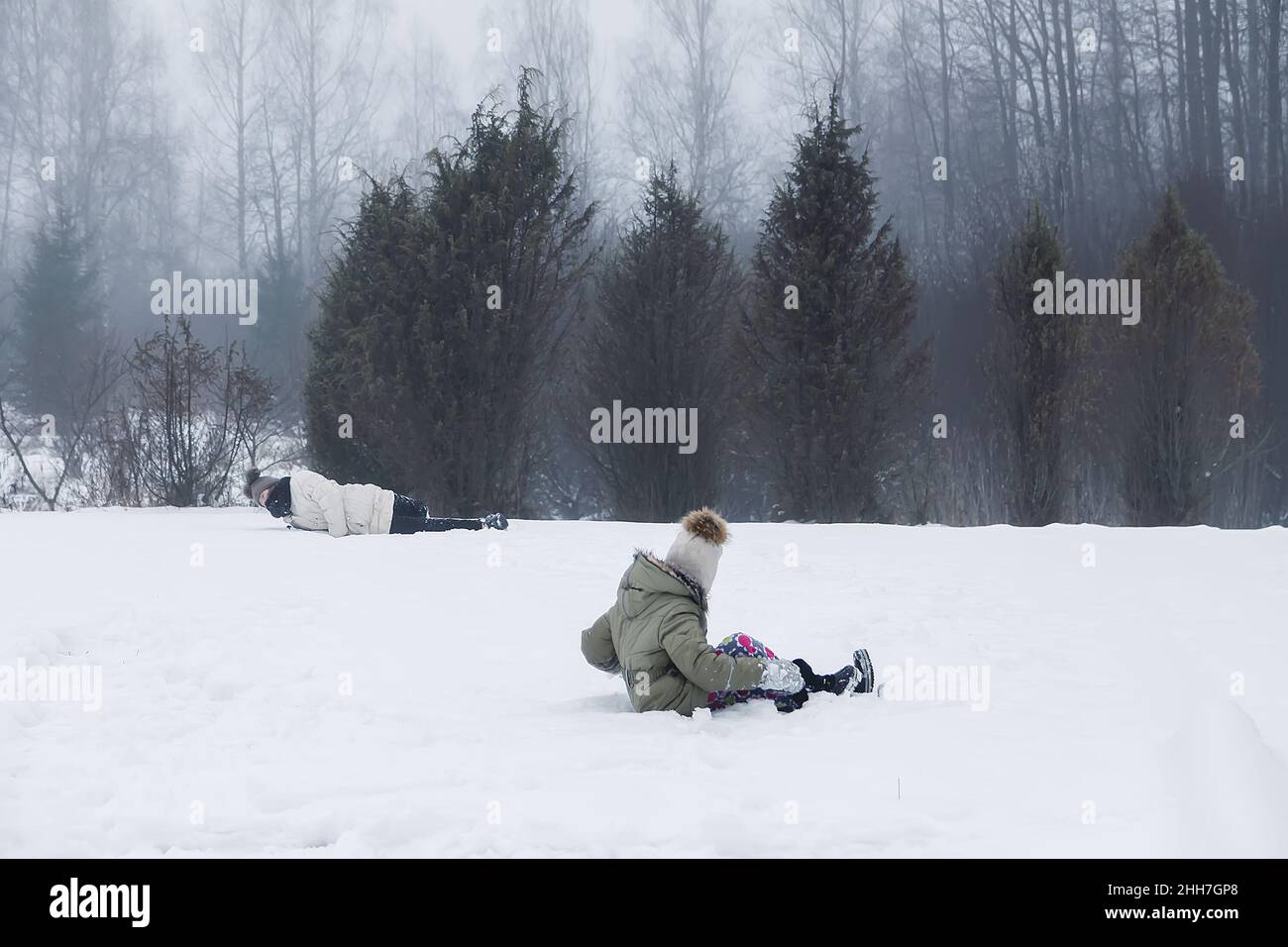 Glückliche Kinder Mädchen spielen in einem schneebedeckten Feld in der Auf dem Land Stockfoto