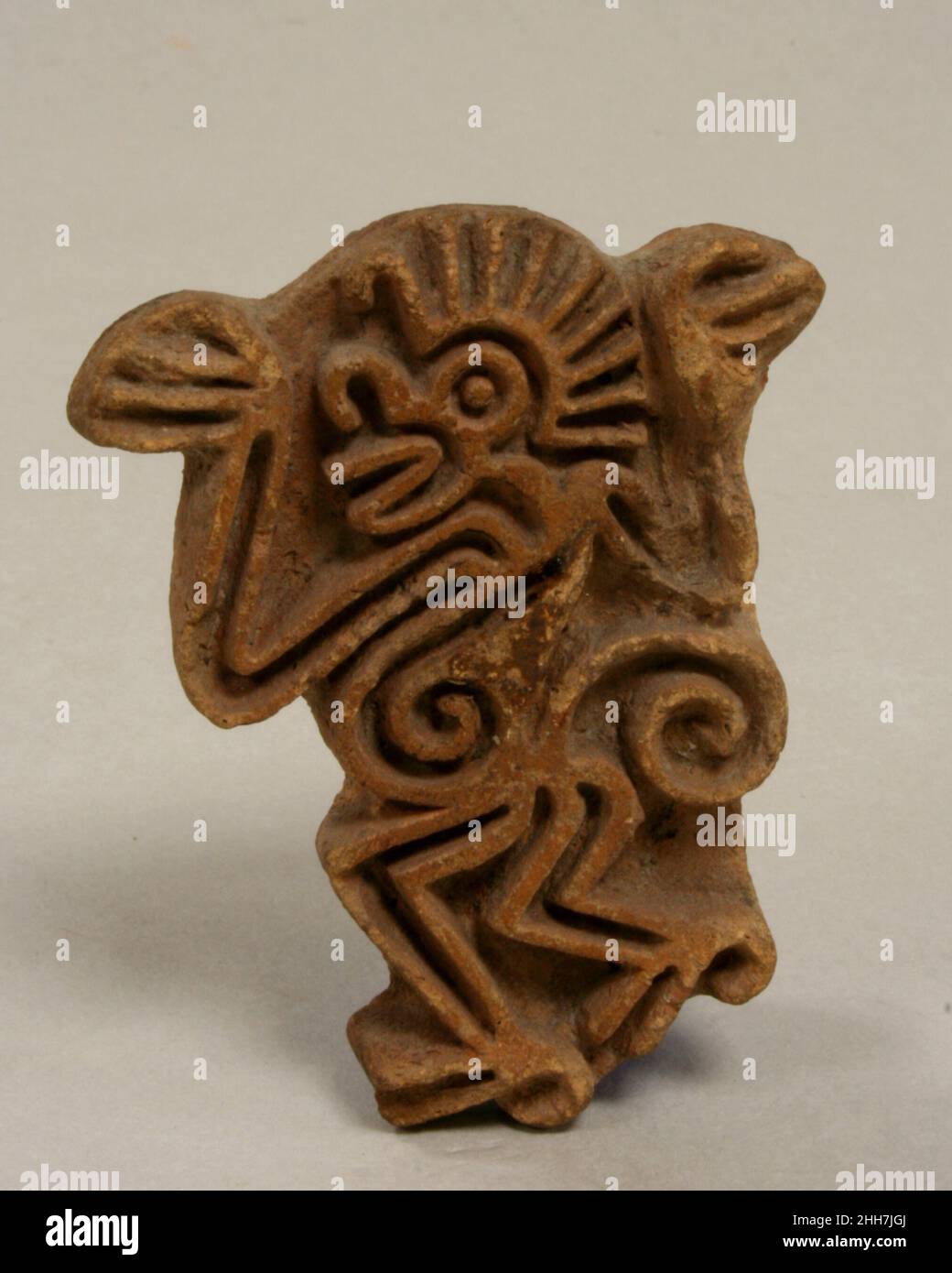 Stempel, Affe 14th–Anfang des 16th. Jahrhunderts Azteken Diese Keramikmarke zeigt das Bild eines Affen im Profil, dessen Arme auf beiden Seiten des Kopfes gestreckt sind. Die parallelen Linien, die von der Krone des Affen ausgehen, ähneln dem Schock ungepfter Haare des mexikanischen Spinnenaffen. Seine aufrechte Haltung und die gebeugten Knie erzeugen ein Gefühl von Bewegung in der Figur – als würde sie gehen –, während ihr rotunder, spiraliger Bauch ein spielerisches Element der Abstraktion ist. Wie der deutsche Archäologe Eduard Seler vor langer Zeit bemerkte, war der Spinnenaffe im alten Mexiko mit den Themen Musik, Tanz und Clowning verbunden.I Stockfoto