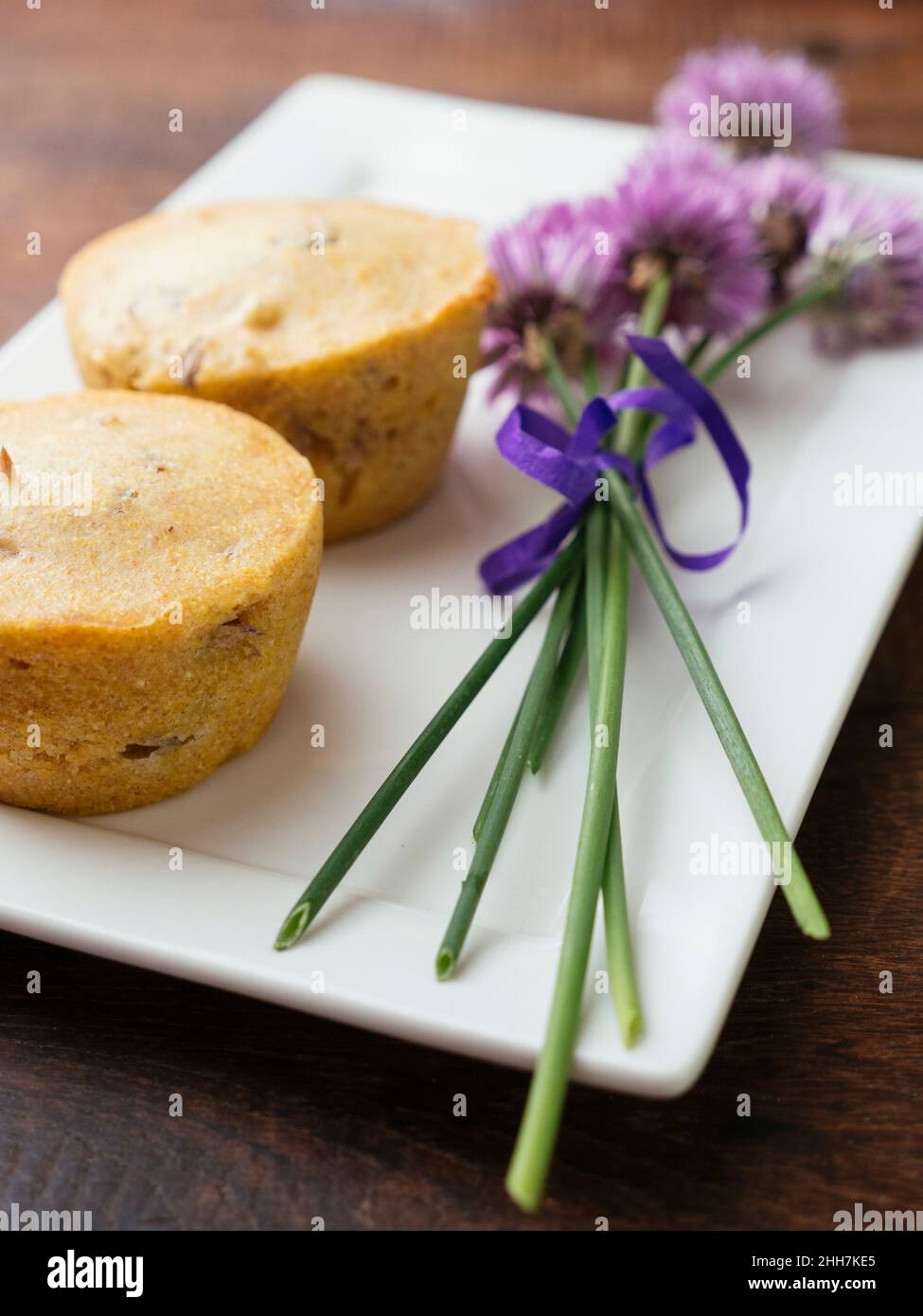Hausgemachte vegane Maisbrot-Muffins mit Chive Blossom-Blüten Stockfoto