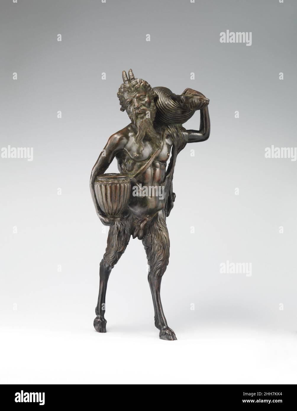 Pan ca. 1510–20 Andrea Briosco, Riccio italienisch genannt Andrea Briosco, Riccio genannt, hat in den halb menschlichen, halb tierischen Merkmalen der mythischen Rasse der Satyrs ein großes Ausdruckspotenzial gefunden. Darüber hinaus appellierten die klassischen Assoziationen der Kreaturen an die gelehrte Kundschaft des Bildhauers, der die Bronzestatuetten kaufte, die sein bevorzugtes Medium waren. Diese winzigen Objekte könnten auch zu nützlichen Schreibtischgeräten für das Schreiben oder die Beleuchtung gemacht werden, indem Behälter für Tinte, Sand oder Öl in die Arme der Satyrs gestellt werden. Ein Loch in der Muschel, das von der Figur des Museums getragen wird, hat möglicherweise eine Kette an te gehalten Stockfoto