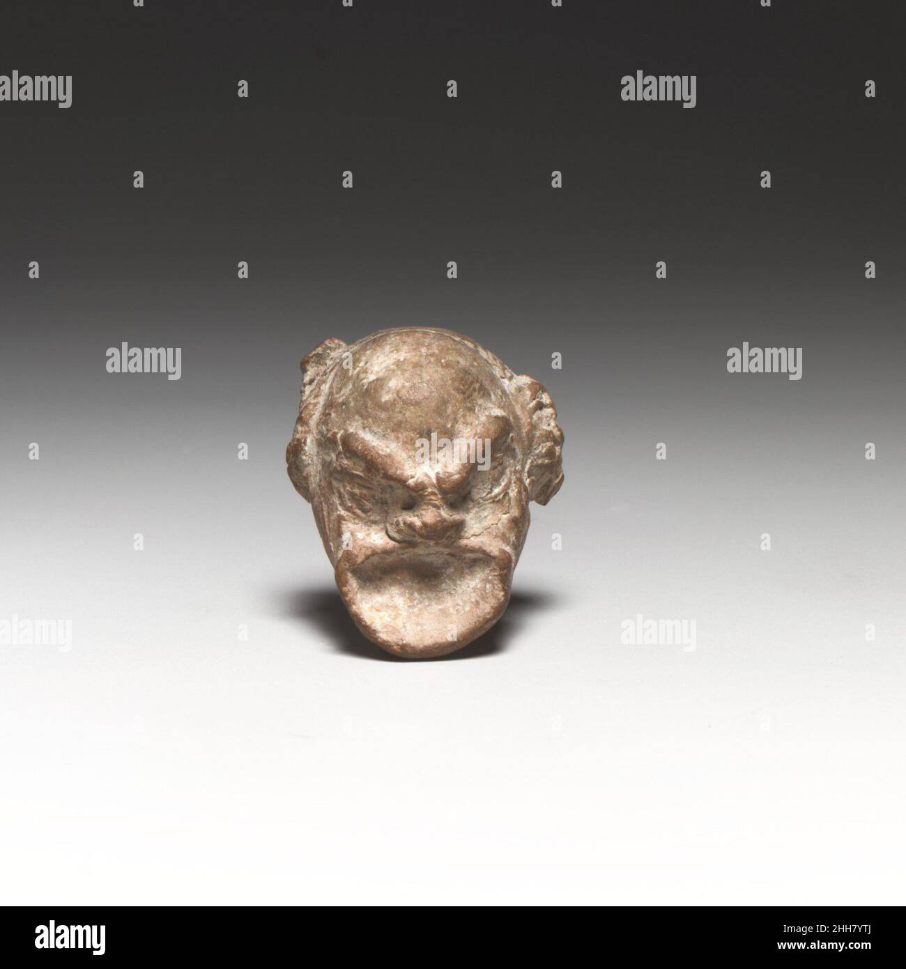 Kopf einer Comic-Figur Ende 4th–3rd Jahrhundert v. Chr. Griechisch, Rhodian ? Der maskierte Kopf ist formgegossen und solide. Die Rückseite fehlt. Kopf einer Comic-Figur 240993 Stockfoto