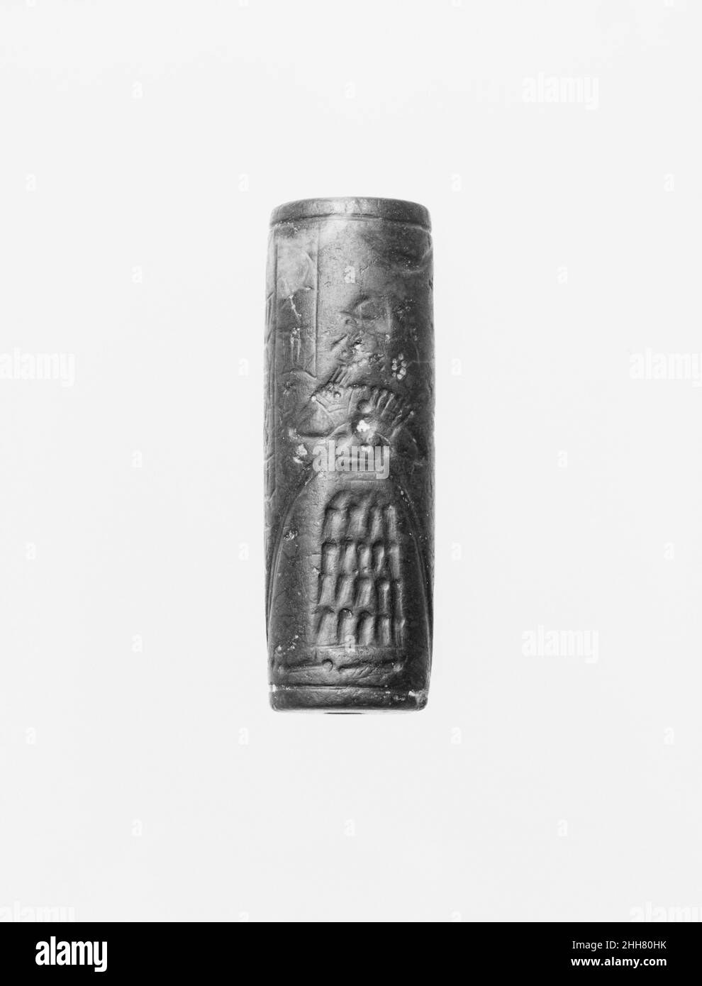 Zylinderdichtung und moderner Eindruck: gott mit fließender Vase; Greifzendämon ca. 12th. Jahrhundert B.C. Assyrian Obwohl gravierte Steine bereits im siebten Jahrtausend B.C. verwendet worden waren, um Eindrücke in Ton zu stempeln, erlaubte die Erfindung im vierten Jahrtausend B.C. der geschnitzten Zylinder, die über Ton gerollt werden konnten, die Entwicklung von komplexeren Siegelentwürfen. Diese Zylinderdichtungen, die zuerst in Mesopotamien verwendet wurden, dienten als Besitzzeichen oder Identifikationszeichen. Dichtungen wurden entweder auf Tonklumpen eingeprägt, die zum Schließen von Gläsern, Türen und Körben verwendet wurden, oder sie wurden auf Tontafeln gerollt, die r Stockfoto
