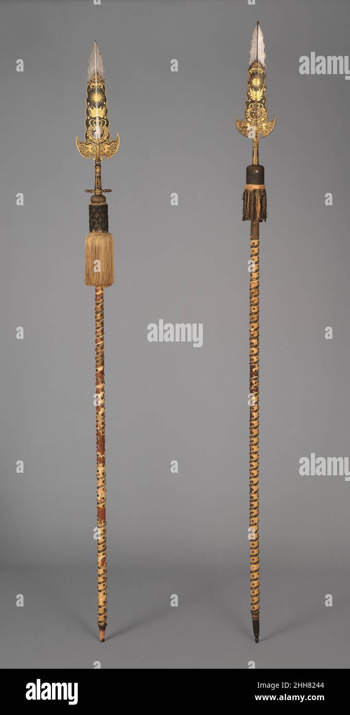 Drei Partisanen, getragen von der Leibwache Ludwigs XIV. (1638–1715, regierte ab 1643) ca. 1658–1715 14.25.454 Entworfen von Jean Berain Französisch werden diese Partisanen vermutlich von den Gardes de la Manche (wörtlich „Hüter der Hülle“, was ihre Nähe zum König anzeigt), einer Eliteeinheit des Leibwächters von Louis XIV., getragen Das zentrale Beispiel stammt aus einer kleinen Gruppe, die Jean Bérain der Ältere (1637–1711) für die Hochzeit von Ludwigs Nichte Marie-Louise d’Orléans mit Carlos II. Von Spanien im Jahr 1679 entworfen hatte. Die Dekoration ist mit einem Sonnenaufstand verziert, der von dem Motto des Königs, NEC PLURIBUS I, überragt wird Stockfoto