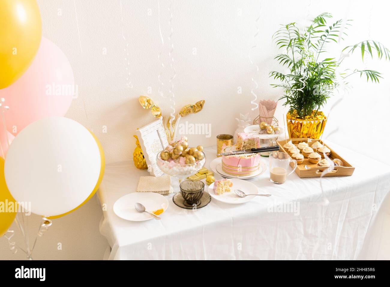 Tisch mit Essensresten nach dem Geburtstag mit Kaffee, Kuchen, Cupcakes Stockfoto