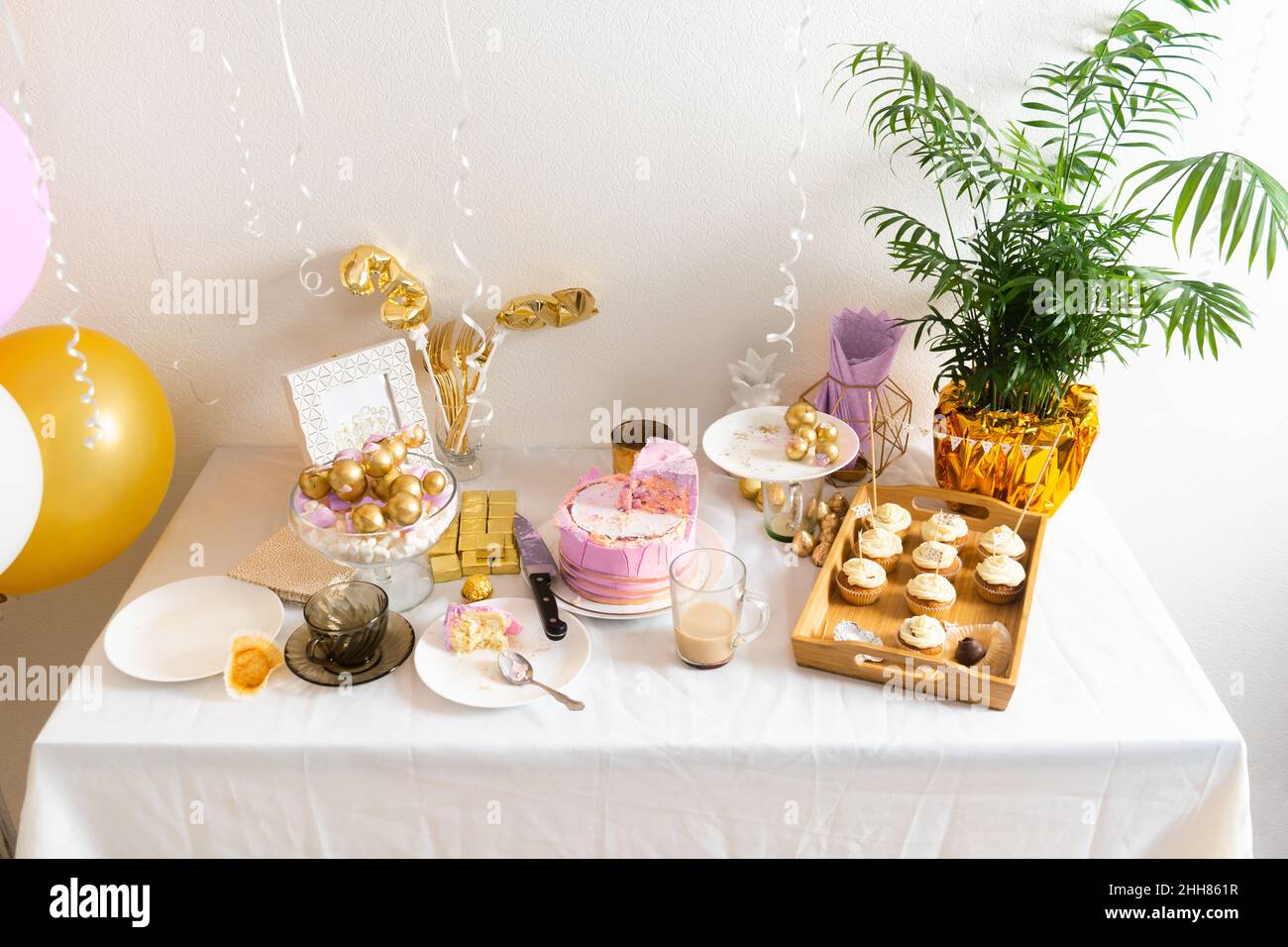 Tisch mit Essensresten nach dem Geburtstag mit Kaffee, Kuchen, Cupcakes Stockfoto