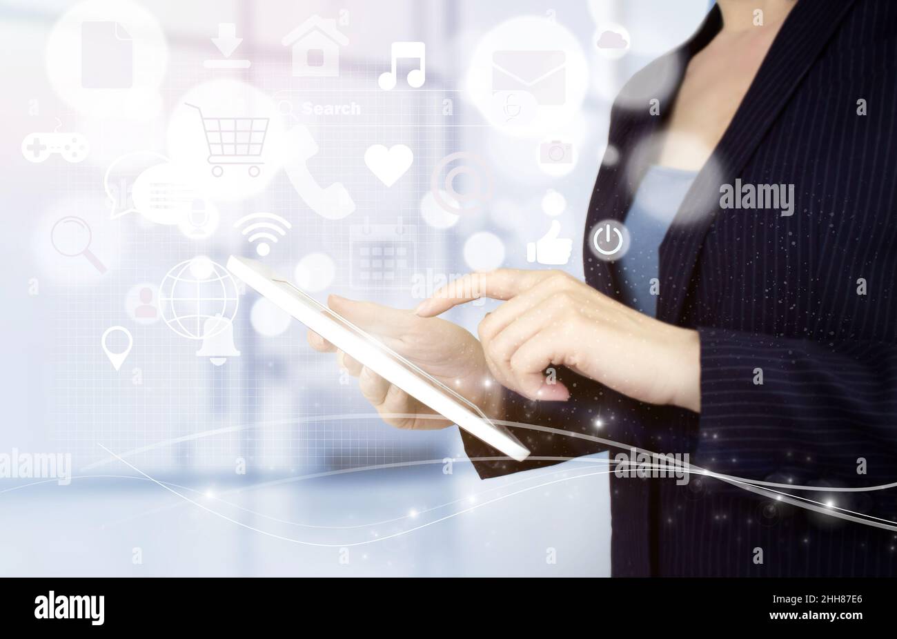 Social Media und digitales Online-Konzept. Weißes Tablet mit Touch-Bedienung und Symbolen für digitale Hologramme in sozialen Medien auf hellem, unscharfem Hintergrund. Soziale Medien Stockfoto