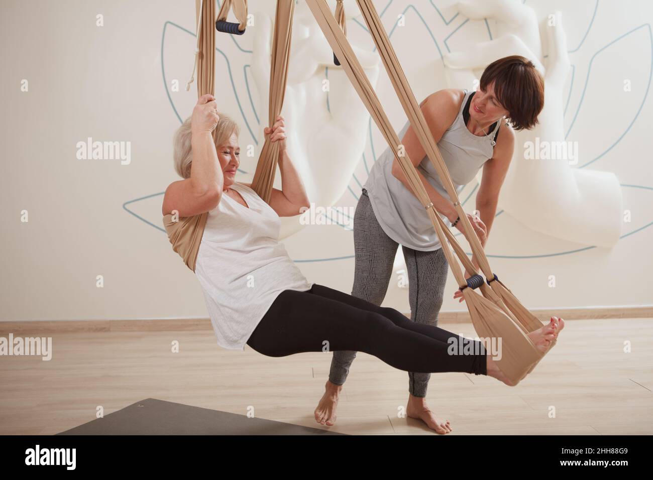 Ältere Frau genießt den Yoga-Kurs mit einem professionellen Lehrer Stockfoto