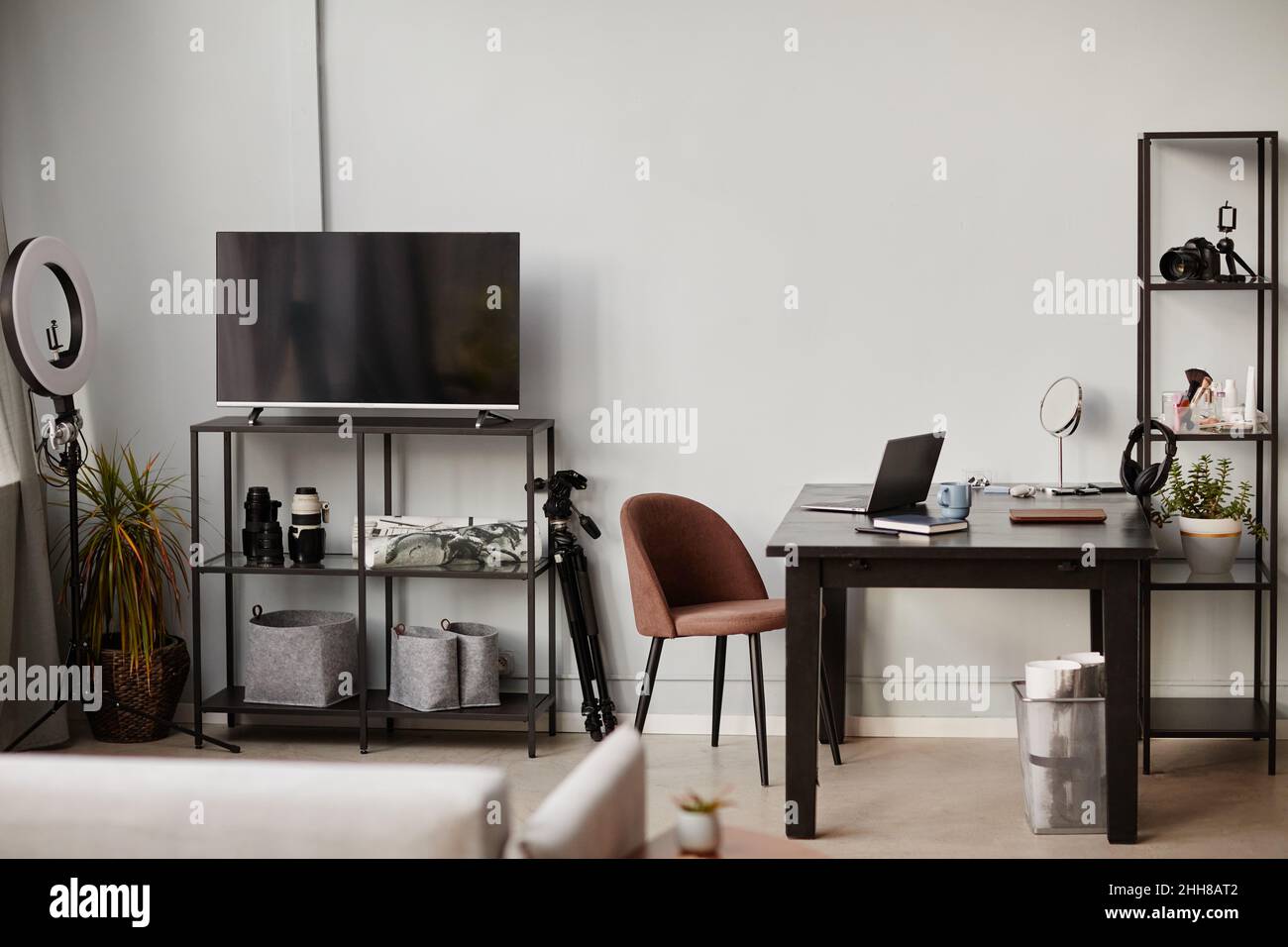 Hintergrundbild von minimalem Heimarbeitsplatz mit Loft-Design-Elementen und Filmausrüstung, Kopierraum Stockfoto