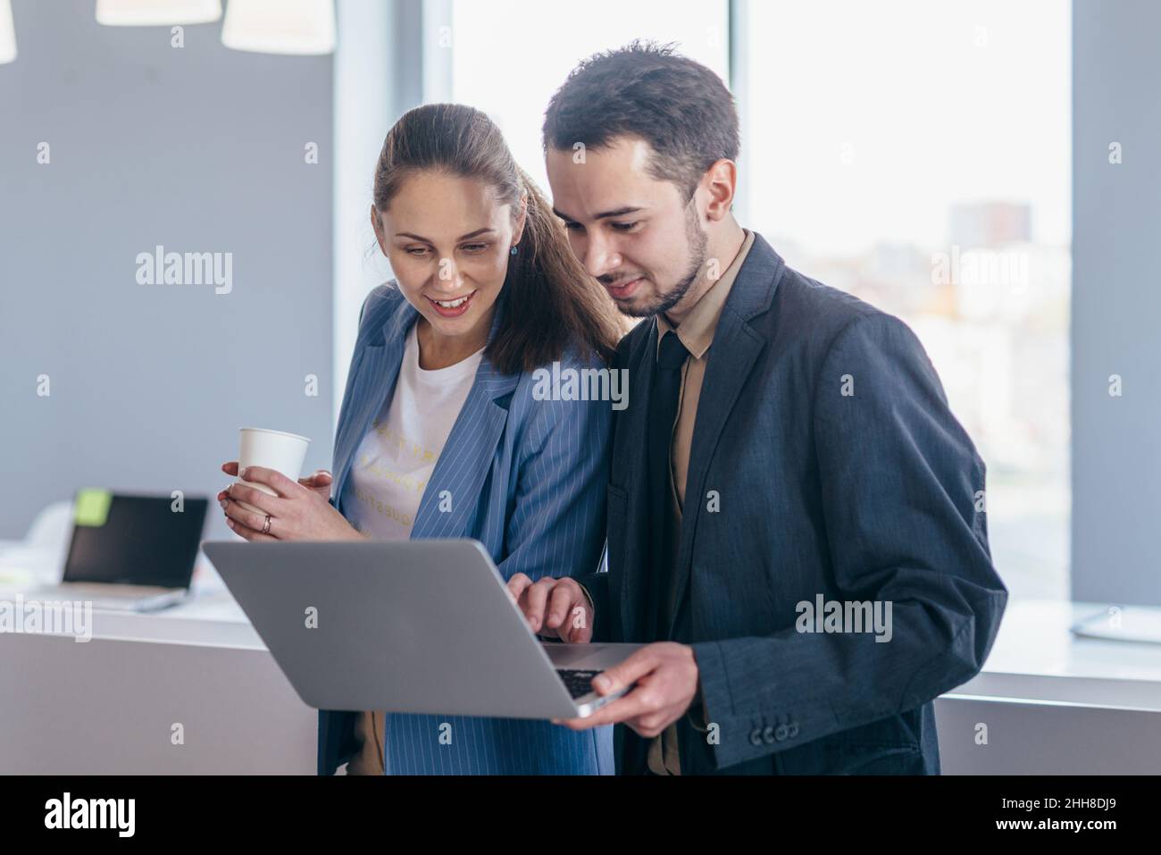 Mitarbeiter stehen im Büro und nutzen den Laptop. Stockfoto