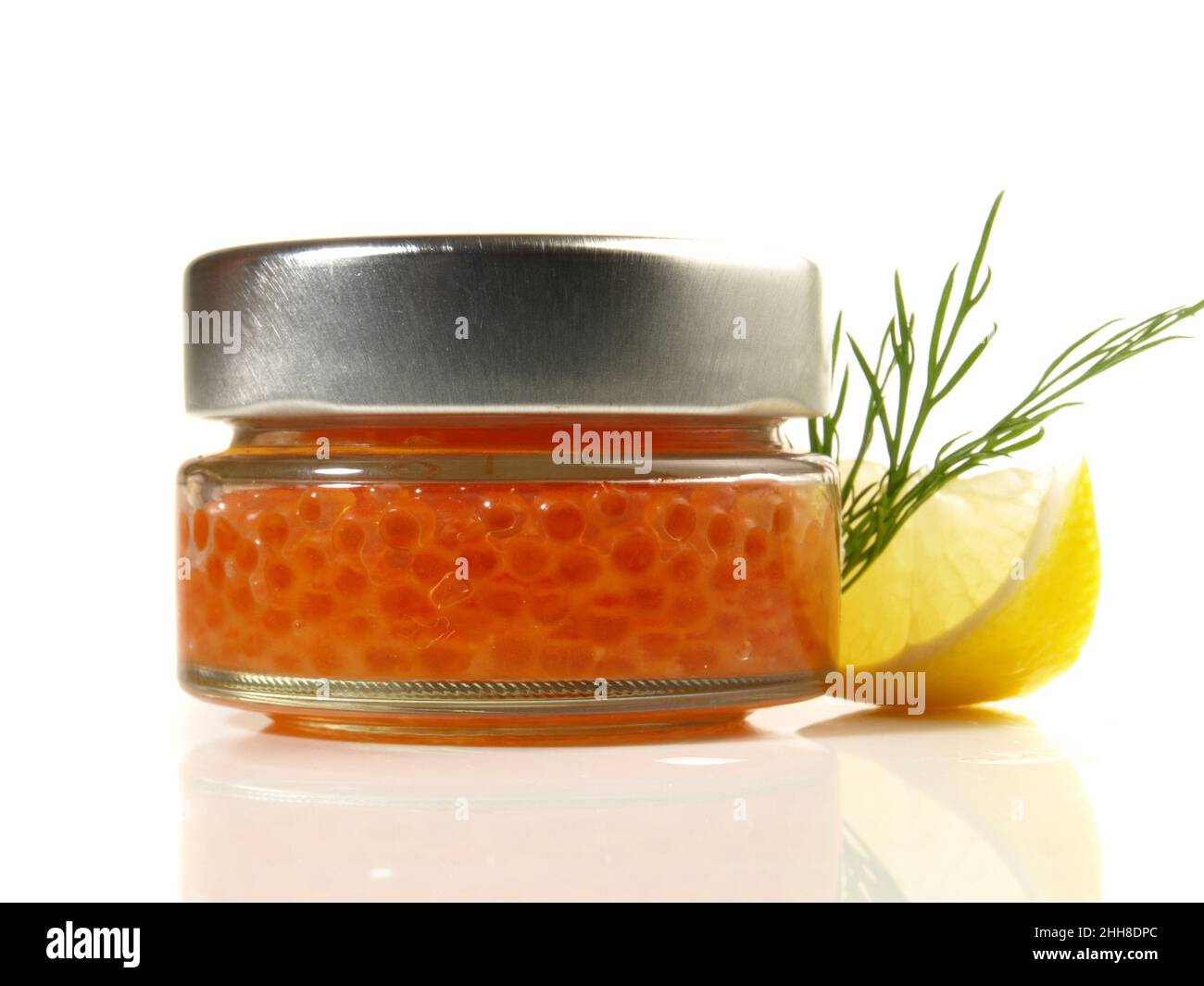 Forellenkaviar in einem Glas mit Lemaon isoliert auf weißem Hintergrund Stockfoto