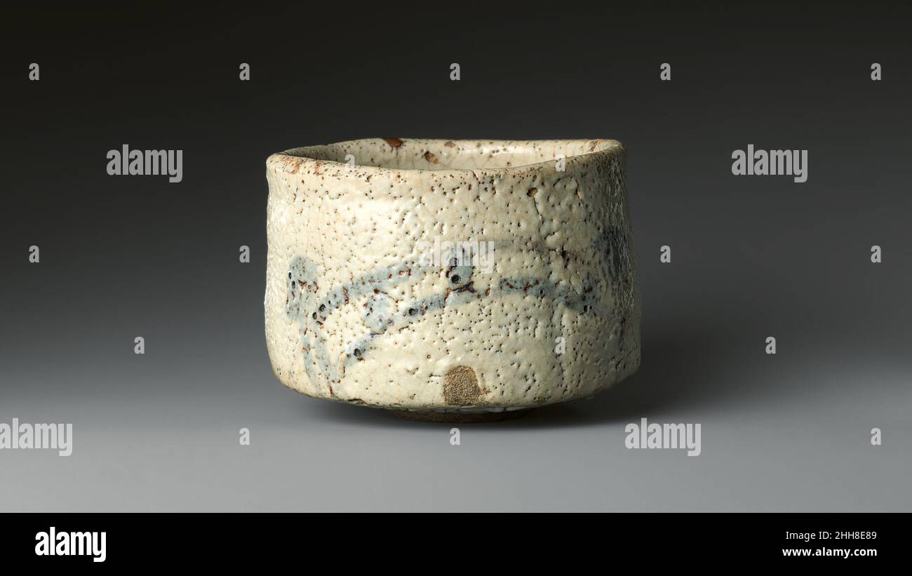 Shino Teabuhu mit Brücke und Haus, bekannt als „Brücke der Götter“ (Shinky?) Ende des 16th. Jahrhunderts Japan Diese Shino-Ware Teeschale hat ein lineares Design einer Brücke und eines schintoistischen Schreines. Die gewölbte Brücke ist mit zwei parallelen Linien gezeichnet, und ihre Säulen sind durch vier vertikale Striche gekennzeichnet. Die Geländer werden durch kurze Linien dargestellt, die aus dem Körper der Brücke hervorgehen. Die Anwendung von reichem Eisenoxid unter der dicken weißen Glasur erzeugt die Illusion einer nebligen Landschaft. Einige Shino-Teeschalen mit ähnlichen stilisierten Kompositionen wurden mit Kapitel 45, „die Göttliche Prinzessin bei Uji“, in Verbindung gebracht Stockfoto