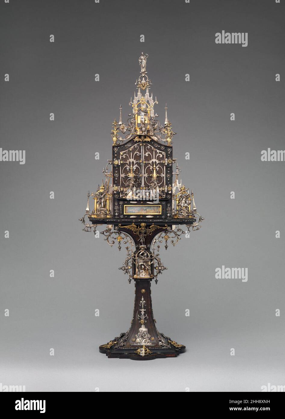 Schrein 1598–1600 Matthias Walbaum Dieses Miniatur-Triptychon Ist eine großartige Vitrine aus verschiedenen Materialien und Techniken und wurde entworfen, um die privaten Andachten seines Besitzers (vielleicht eines der Kardinäle Madruzzo, aufeinanderfolgende Fürstbischöfe von Trient) zu inspirieren. Mit Edelmetalltrazerie auf teures Ebenholz aufgetragen, laden seine aufklappbaren Holztüren zum Handling ein. Sie führen nicht in eine kleine gotische Kapelle, sondern in eine illusionistische nächtliche Landschaft, in der Gläubige das Christkind anbeten. Beide Künstler unterzeichneten diese glorreiche Zusammenarbeit; Walbaum, als einer der renommiertesten Goldschmiede des wohlhabenden Augsburgs, wou Stockfoto