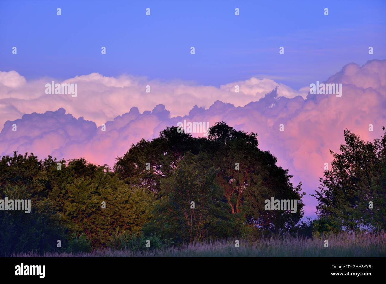 Bartlett, Illinois, USA. Schichten angesammelter Wolken am späten Nachmittag spiegeln an einem späten Frühlingsabend das Licht eines farbenfrohen Sonnenuntergangs wider. Stockfoto
