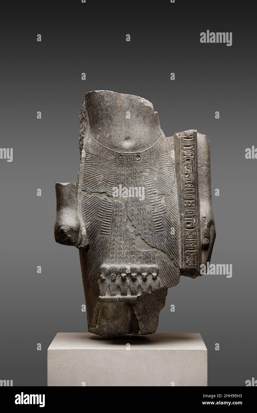 Fragmentarische Statue von Ramesses II als Standartträger ca. 1279–1213 v. Chr. Neues Königreich, Ramesside in diesem Teil einer Tempelstatue hält Ramesses II. Den Stab eines heiligen Standards mit seiner linken Hand und stellt ihn gegen seine Seite und Schulter (siehe 65,114 für ein nicht-königliches, aber vollständiges Beispiel einer Standartstatue). Gekrönt mit königlichen oder göttlichen Figuren (oder ihren Köpfen), stellten solche Standards entweder die Lebenskraft des Königs (ka) dar oder dienten als tragbare Götterbilder. Indem er dieses Objekt hielt, lenkte der König die Aufmerksamkeit auf seine fleißige Ausführung des Tempelrituals. Die Inschriften auf dem Shaf Stockfoto