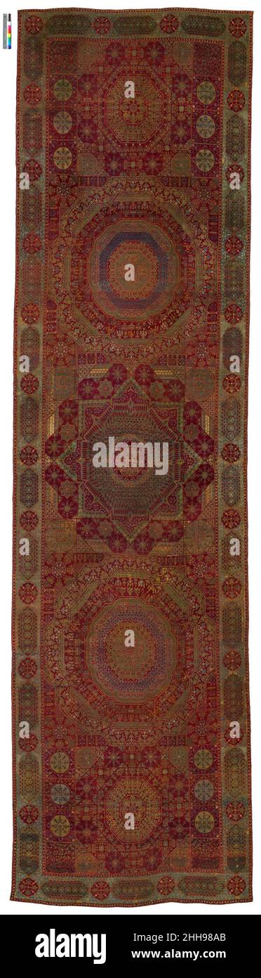 Der 'Simonetti' Teppich ca. 1500 benannt nach einem ehemaligen Besitzer, ist diese majestätische Weberei einer der berühmtesten aller Mamluk-Teppiche. Eines der größeren Bodenbeläge seiner Art, dieses Beispiel hat fünf Medaillons anstelle des üblichen ein oder drei, und es zeigt eine etwas hellere und abwechslungsreichere Palette. Wahrscheinlich in Ägypten unter der Mamluk-Dynastie hergestellt, sind solche Teppiche überraschend reich an Aussehen angesichts ihrer relativ groben Webart und begrenzten Farbpalette. Der Gesamteffekt ist der eines leuchtenden Mosaiks. Hören Sie zu, wie Experten die Kunst beleuchten Stockfoto