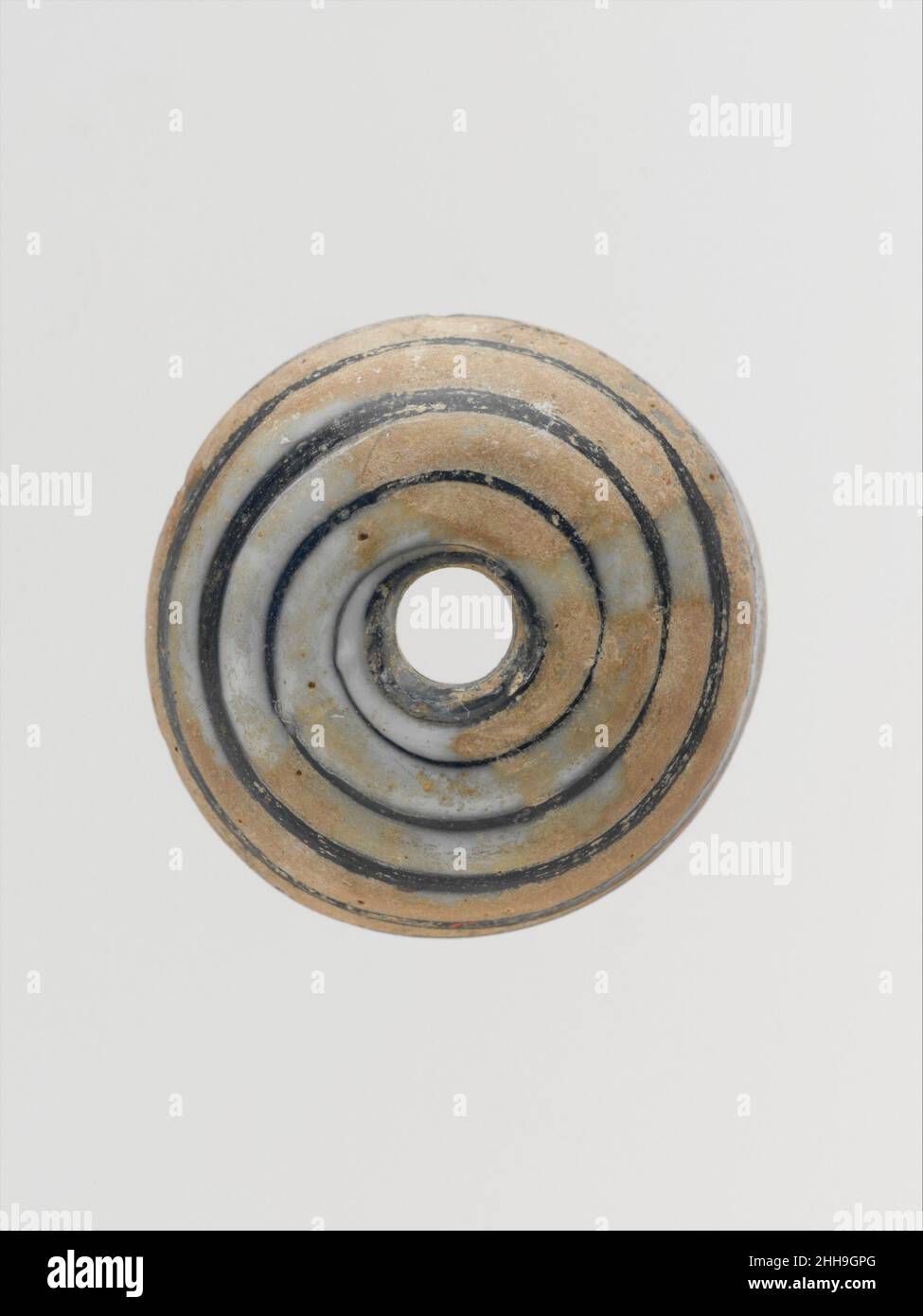 Glas-Spindel-Whorl ca. 1st–2nd. Jahrhundert n. Chr. Roman Durchscheinendes Kobaltblau, mit opaker weißer Spur.niedriger, gewölbter Körper, in der Mitte leicht abgeflacht; flacher Boden; vertikales Loch.Pfad, der in einer Spirale von der Mitte zur Außenkante auf die obere Oberfläche aufgetragen wird.intakter, aber leichter Span am unteren Rand; Einige dulling und Lochfraß, und Oberflächen weitgehend mit bräunlichen Emaille-wie Verwitterung bedeckt.Made durch Wicklung Spur in einer Spirale um Stab.Blau gewölbte Spindel-Whorl mit dicken weißen Spiralglasfaden.. Spindelwelle aus Glas Roman. Ca. 1st–2nd Jahrhundert n. Chr. Glas; stabförmig, gezogen und gewickelt. Früh bis mittelkaiserlich. Gl Stockfoto