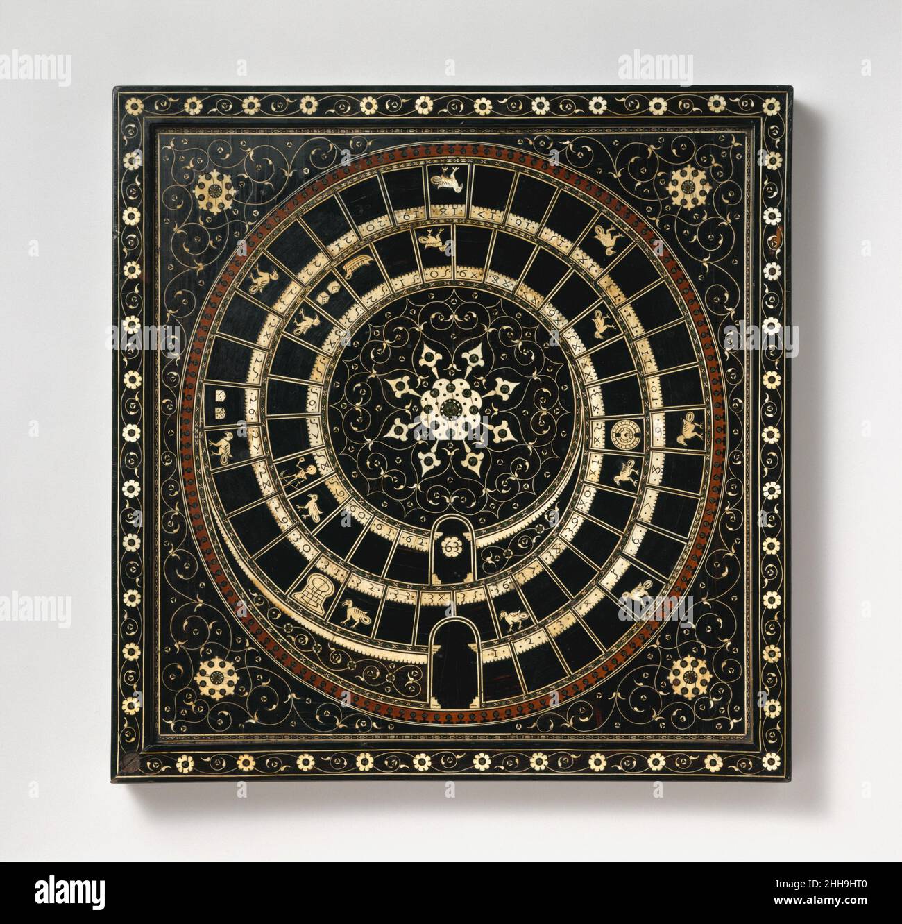 Schach- und Gans-Spielbrett Ende des 16th. Jahrhunderts Indien, Gujarat Dieses Spiel der Gans oder Gans-Spielbrett scheint das älteste Überleben eines Spiels zu sein, das erstmals 1480 in Italien erwähnt wurde. Beliebt am Medici-Hof von Florenz, wird es im Juni 1597 von John Wolfe dokumentiert, der bezeugte, dass das Spiel in London gespielt wurde. Es wird angenommen, dass es der Prototyp für viele der kommerziellen europäischen Rennboards der letzten Jahrhunderte ist. Die Inlay-Technik der vorliegenden Tafel wird nach einem gedruckten italienischen Design mit Gujarat aus dem 16th. Jahrhundert in Nordindien in Verbindung gebracht. Solche kostbaren Gegenstände wurden sehr geschätzt Stockfoto