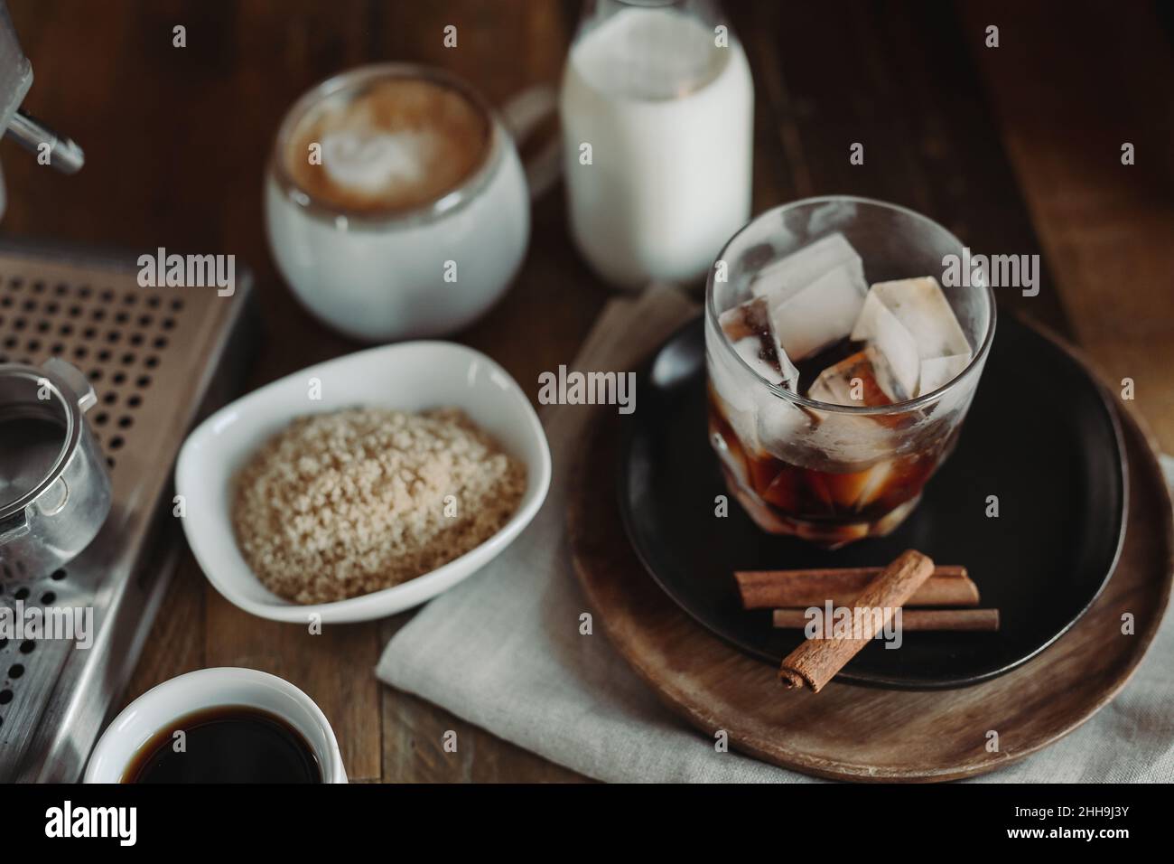 Zutaten Für Iced Brown Sugar Hafermilch Latte. Prozess der Herstellung von Eiskaffee. Moody Coffee Shop Lifestyle Flat Lay mit Copy Space. Umrühren. Stockfoto