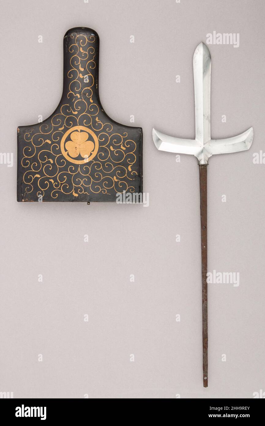 Klinge für einen Speer (J?monji-yari) mit Scheide vom August 1727 Klinge von Munemichi die Verwendung von Speeren wurde in der späten Muromachi-Zeit (1392–1573), einer Zeit nahezu ständiger militärischer Konflikte, immer häufiger. Stichwaffen, die zu Fuß eingesetzt werden konnten, wurden in der Regel etwa 7 Fuß lang gemessen, was eine Manövrierbarkeit aus nächster Nähe ermöglichte. Speerköpfe variierten in Größe und Form; dieses Beispiel ist von einer Art mit einer kreuzförmigen Struktur. Die Scheide trägt das Wappen (mon) von Matsudaira, einem Zweig des Tokugawa-Shogunats. Klinge für einen Speer (J?monji-yari) mit Scheide. Japanisch. Datum Stockfoto