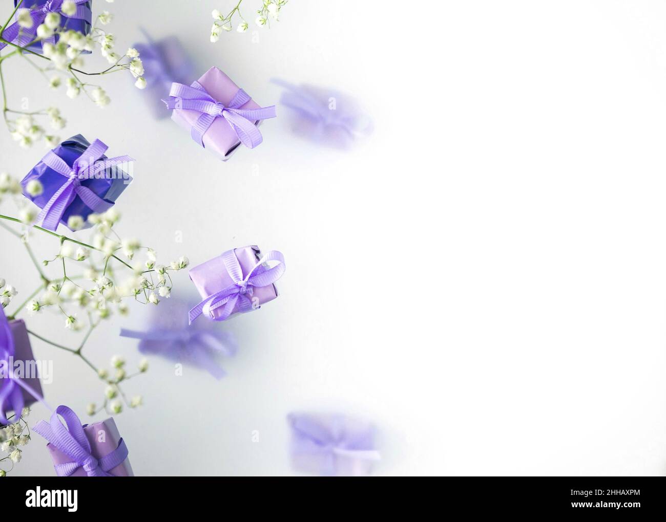 Eine mehrschichtige Postkarte aus Geschenkschachteln in einer modischen, trendigen, sehr perifarbenen Farbe mit weißen Blüten auf einem nebligen Hintergrund. Happy Women Day und Val Stockfoto