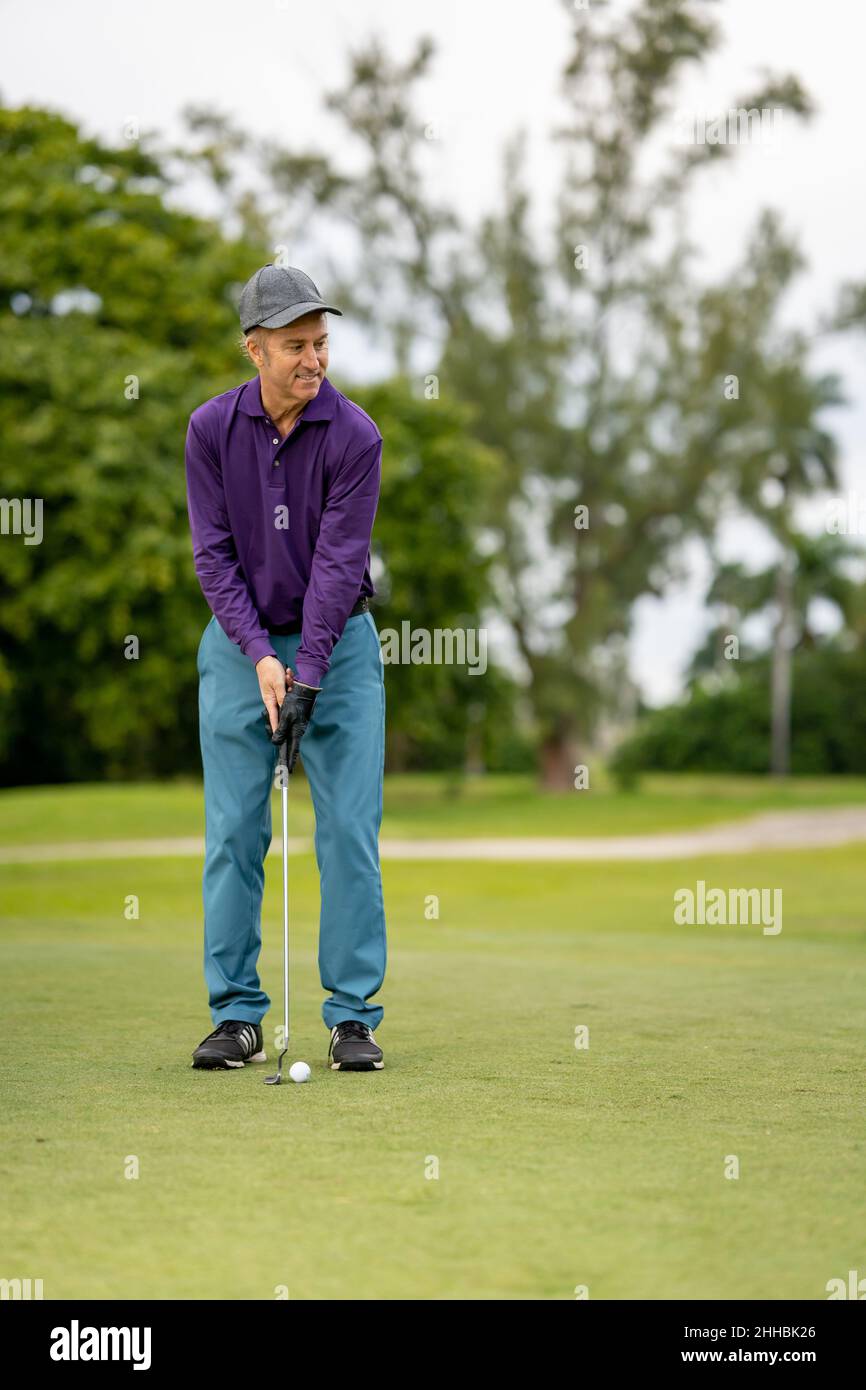 Mann spielt Golf und lächelt Stockfoto