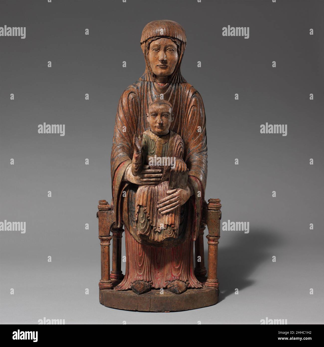 Throned Virgin and Child 1150–1200 Französisch die krassen und rhythmischen Linien dieser Skulptur wirken fast modern. Tatsächlich stellt dieses scheinbar geradlinige Bild des Jesuskindes, das starr auf dem Schoß der Jungfrau sitzt, eine komplexe, mittelalterliche theologische Vorstellung dar, die als Sedes Sapientiae (Thron der Weisheit) bekannt ist, in der Maria als Thron für Christus dient, der wiederum göttliche Weisheit verkörpert. Diese imposante Gruppe, die auf einem Altar aufgestellt wurde, war ein Objekt der Verehrung, das auch in einer Prozession getragen oder in eine Theateraufführung innerhalb einer Kirche integriert werden konnte. Eine kreisförmige Kavität in t Stockfoto