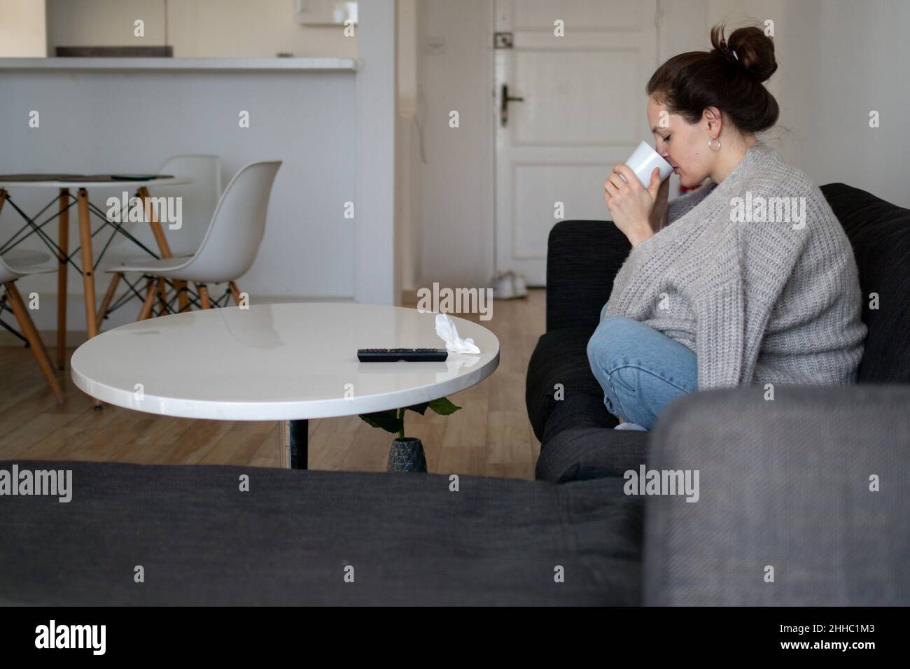 Eine ungesunde Frau trinkt Tee und bleibt zu Hause Stockfoto