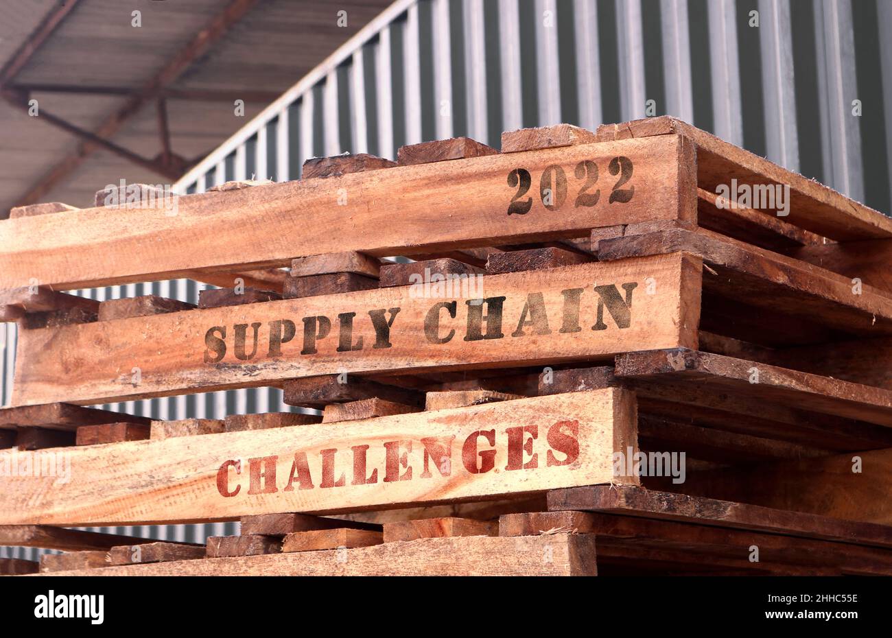 2022 Herausforderungen in der Lieferkette, Text auf aufgestapelten Paletten. Supply Chain- und Logistikkonzept. Stockfoto