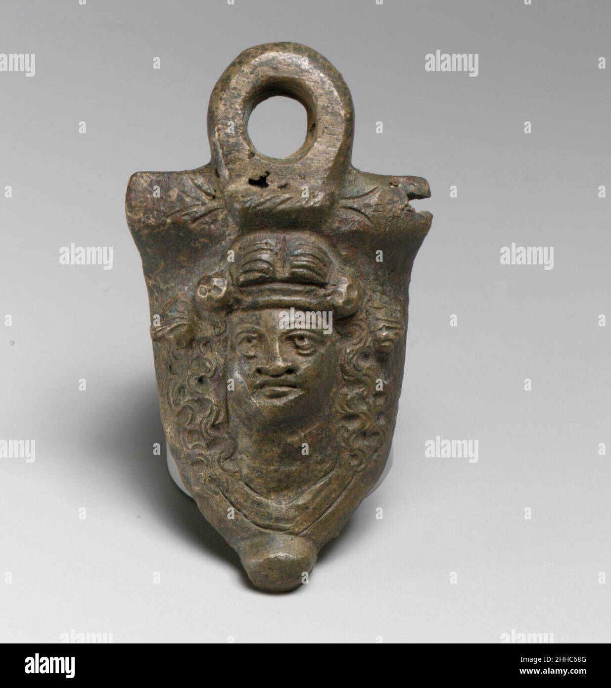 Bronzestiel Befestigung 2nd Jahrhundert A.D. Roman der Griff einmal schmückte die Seite einer Situla (Weineimer), und die umkranzte Maske in hohem Relief kann als die von Dionysus identifiziert werden.. Befestigung mit Bronzestiel 246912 Stockfoto