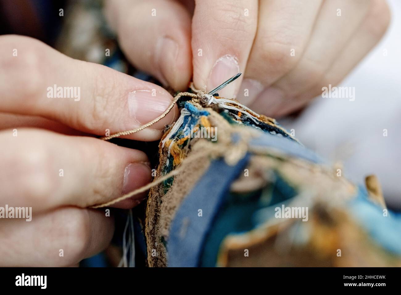 Nahaufnahme Hände des Handwerkers Schneidernähen mit einer Nadel und Faden. Der Schneidermeister arbeitet gerade. Stockfoto