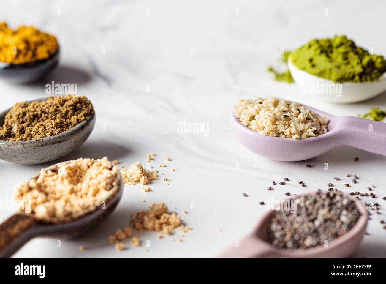 Superfood-Pulver in Löffeln, weißer Marmorhintergrund, Kopierraum. Stockfoto