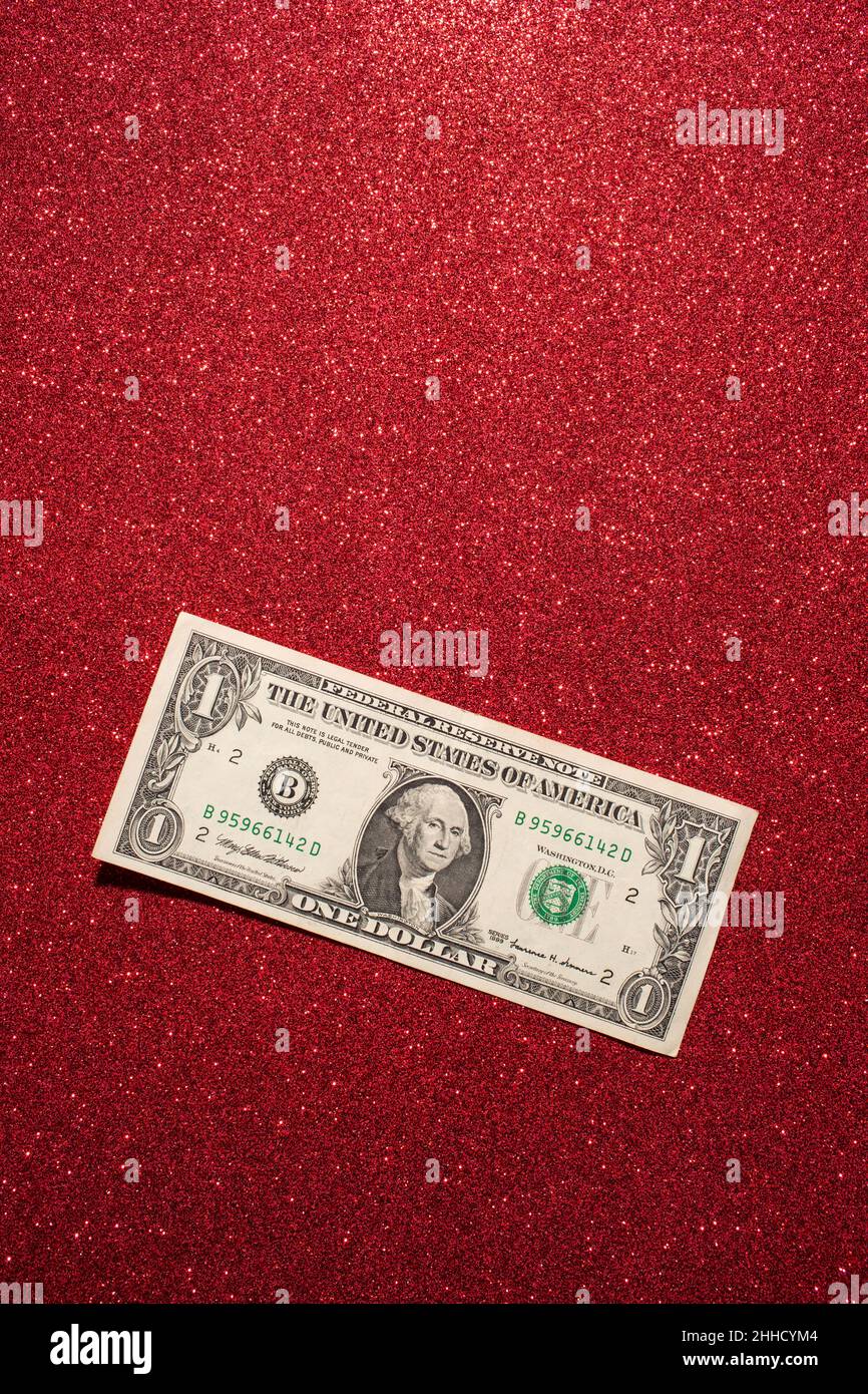 Blick auf einen US-Dollar-Schein auf rot glitzerndem Hintergrund Stockfoto