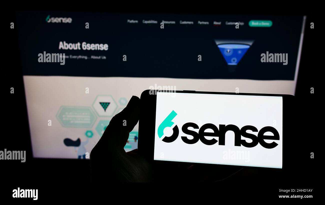 Person, die das Smartphone mit dem Logo des US-amerikanischen Softwareunternehmens 6Sense Insights Inc. Auf dem Bildschirm vor der Website hält. Konzentrieren Sie sich auf die Telefonanzeige. Stockfoto