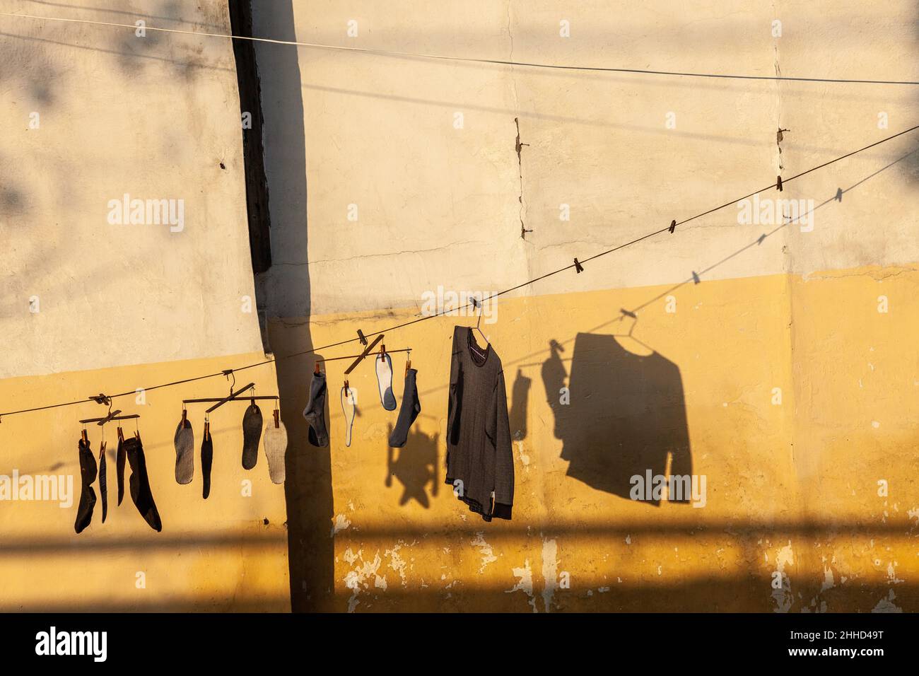 Die Wäsche trocknet in der Morgensonne vor einer ockerfarbenen Wand. Jiashan, China Stockfoto
