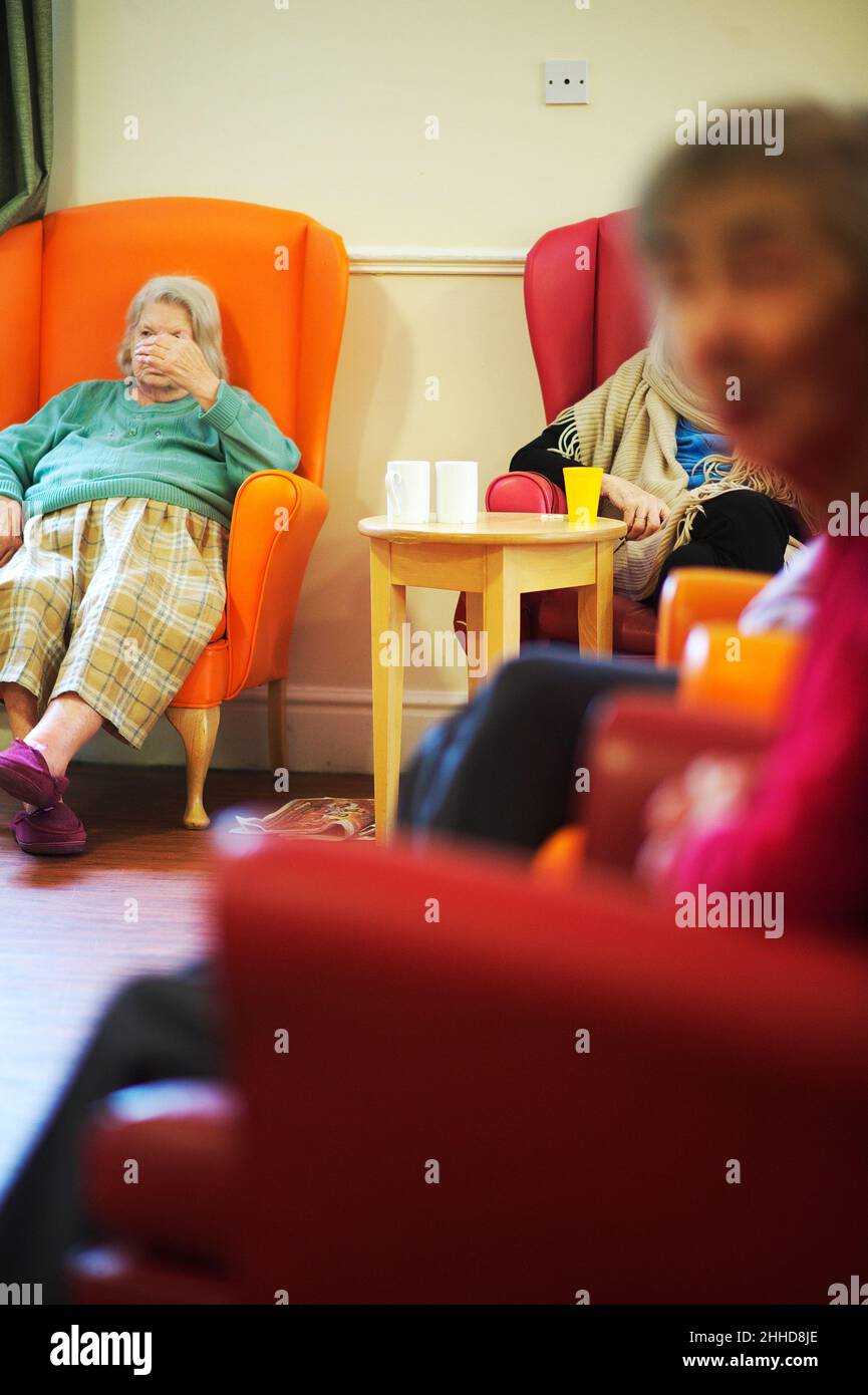Ältere Menschen, die in einem Demenzheim in Großbritannien sitzen Stockfoto